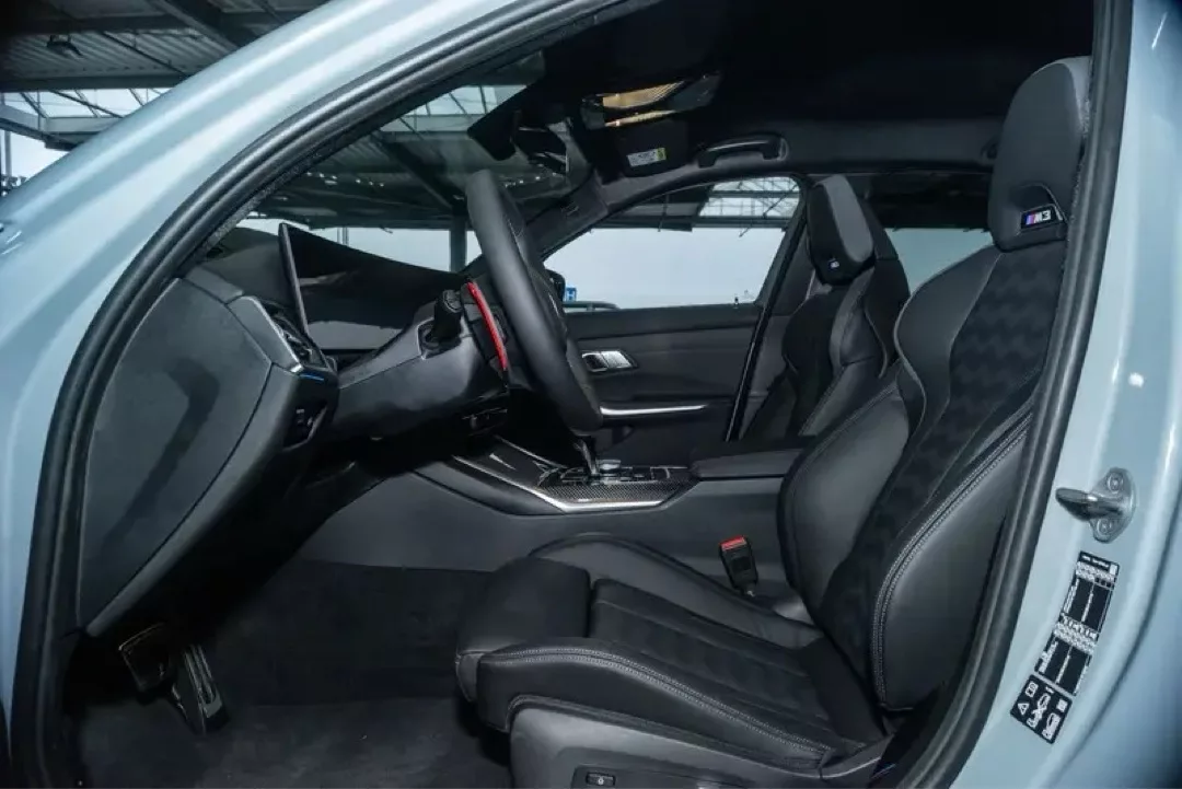 Innenansicht eines BMW M3 Competition mit modernen Sportsitzen und Lenkrad.