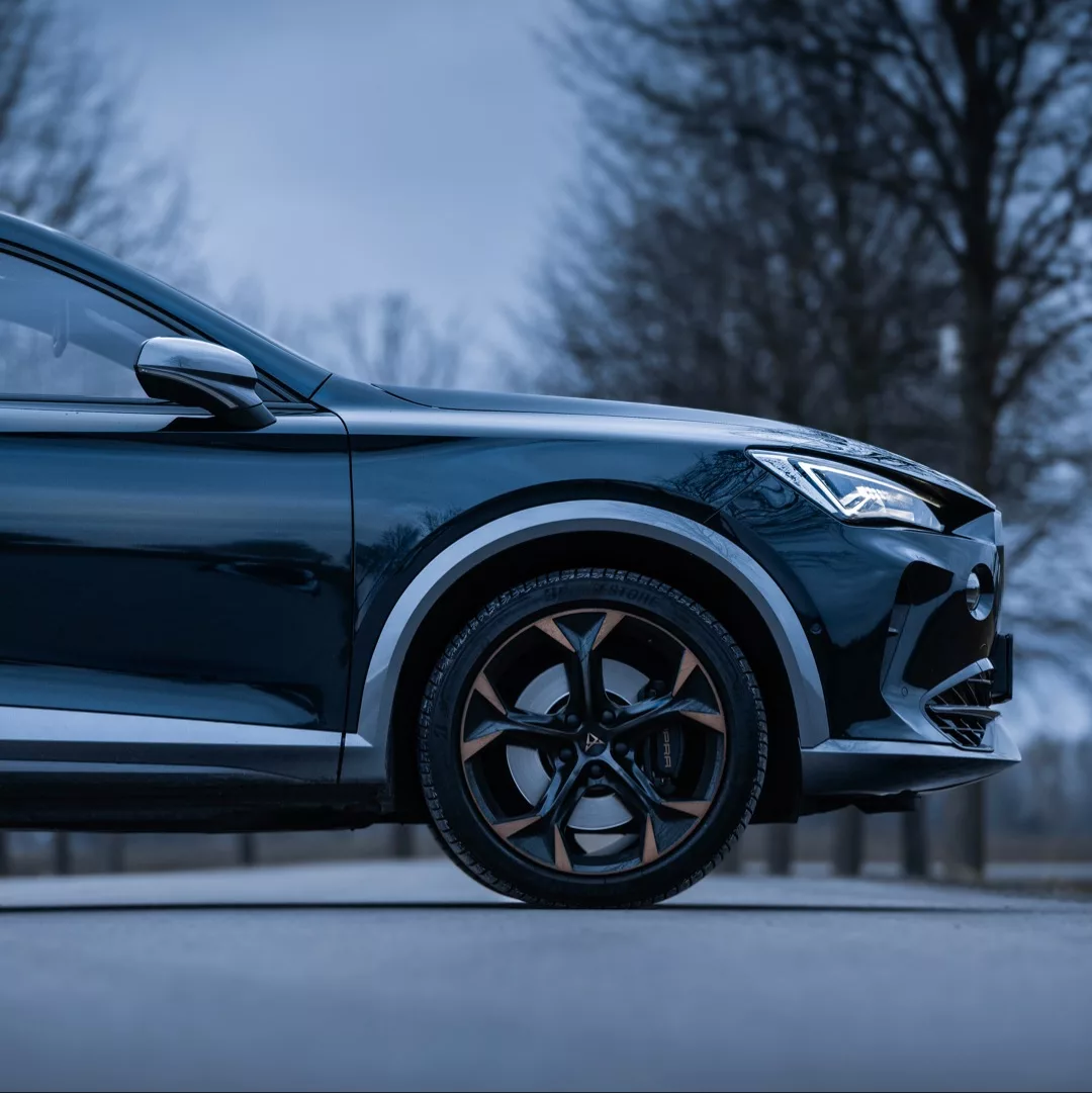 Cupra Formentor VZ in Dunkelblau, Seitenansicht mit offenem Reifen, mieten.