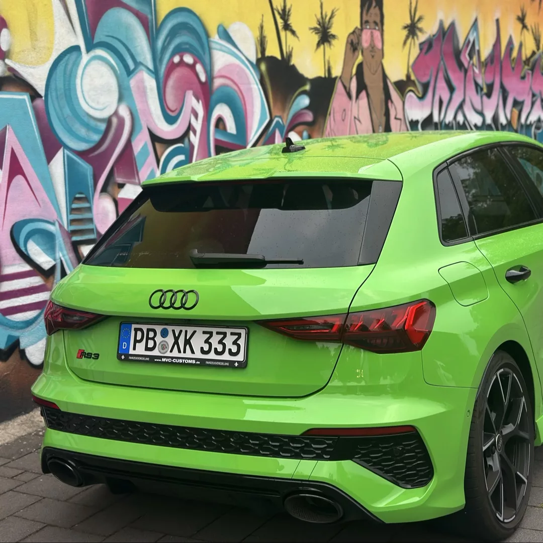 Audi RS3 Sportback in Grün von hinten vor Graffiti mieten.