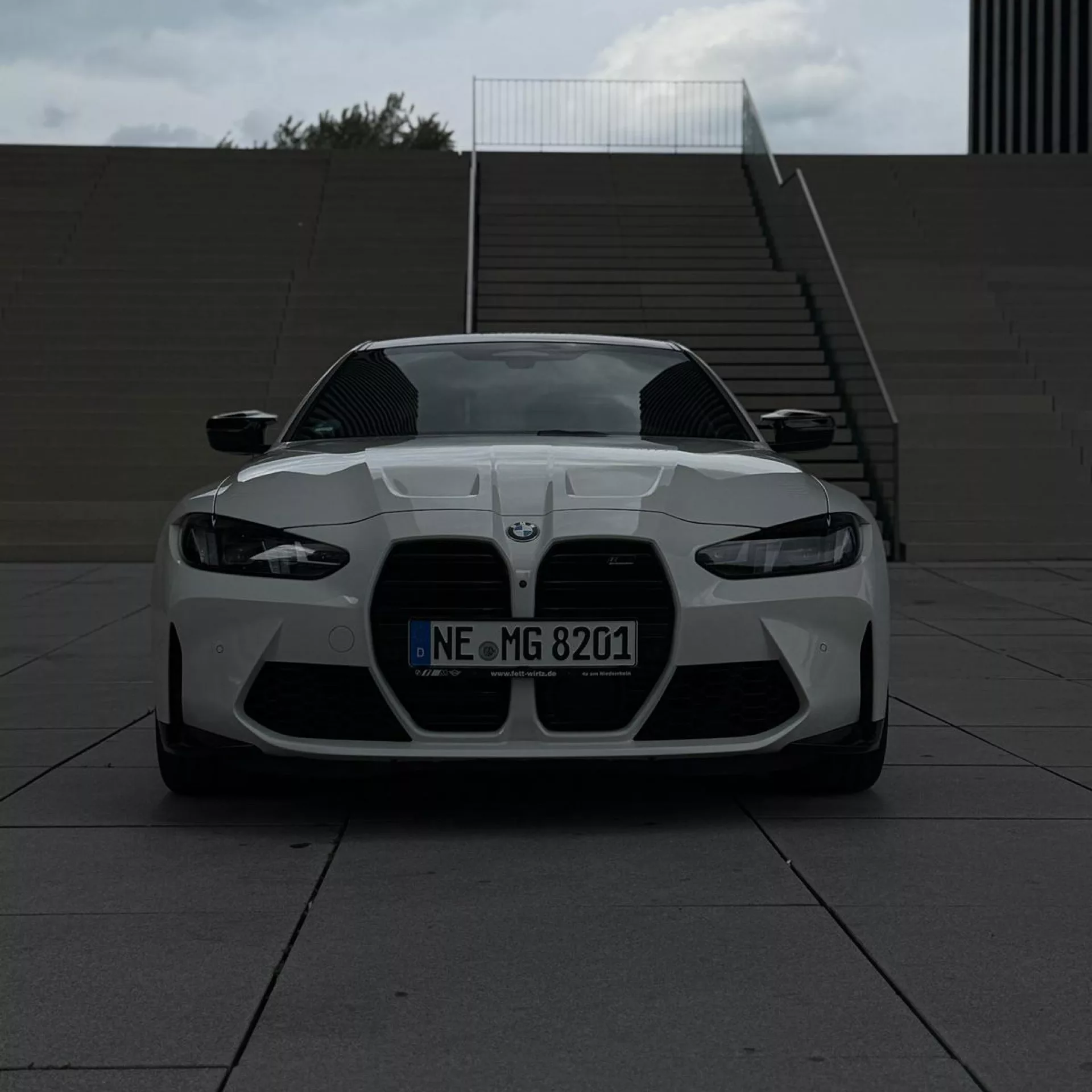 BMW M4 Competition in Weiß mieten - Frontansicht mit Treppen im Hintergrund