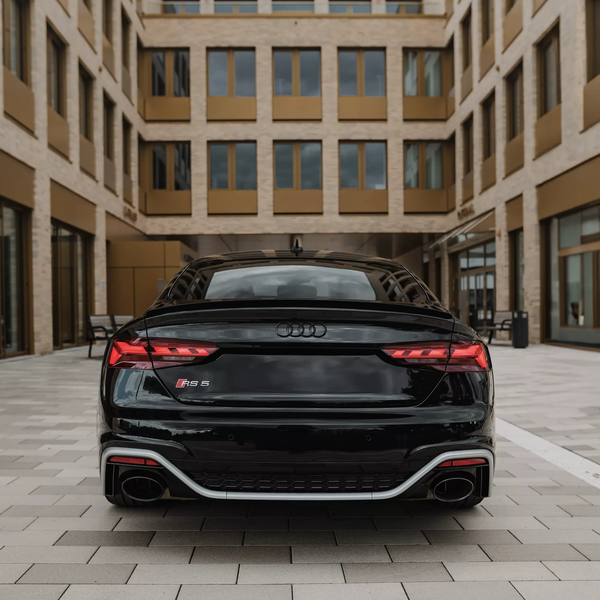 Audi RS5 Sportback in Schwarz, Rückansicht, urbanes Setting mieten