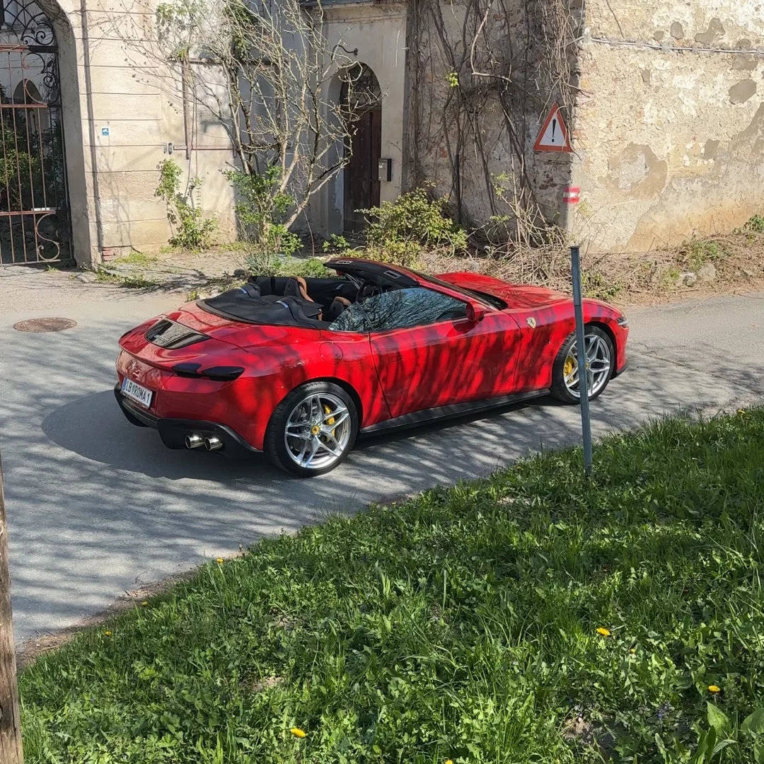 Ferrari Roma Spider in Rot von der Seite mieten.