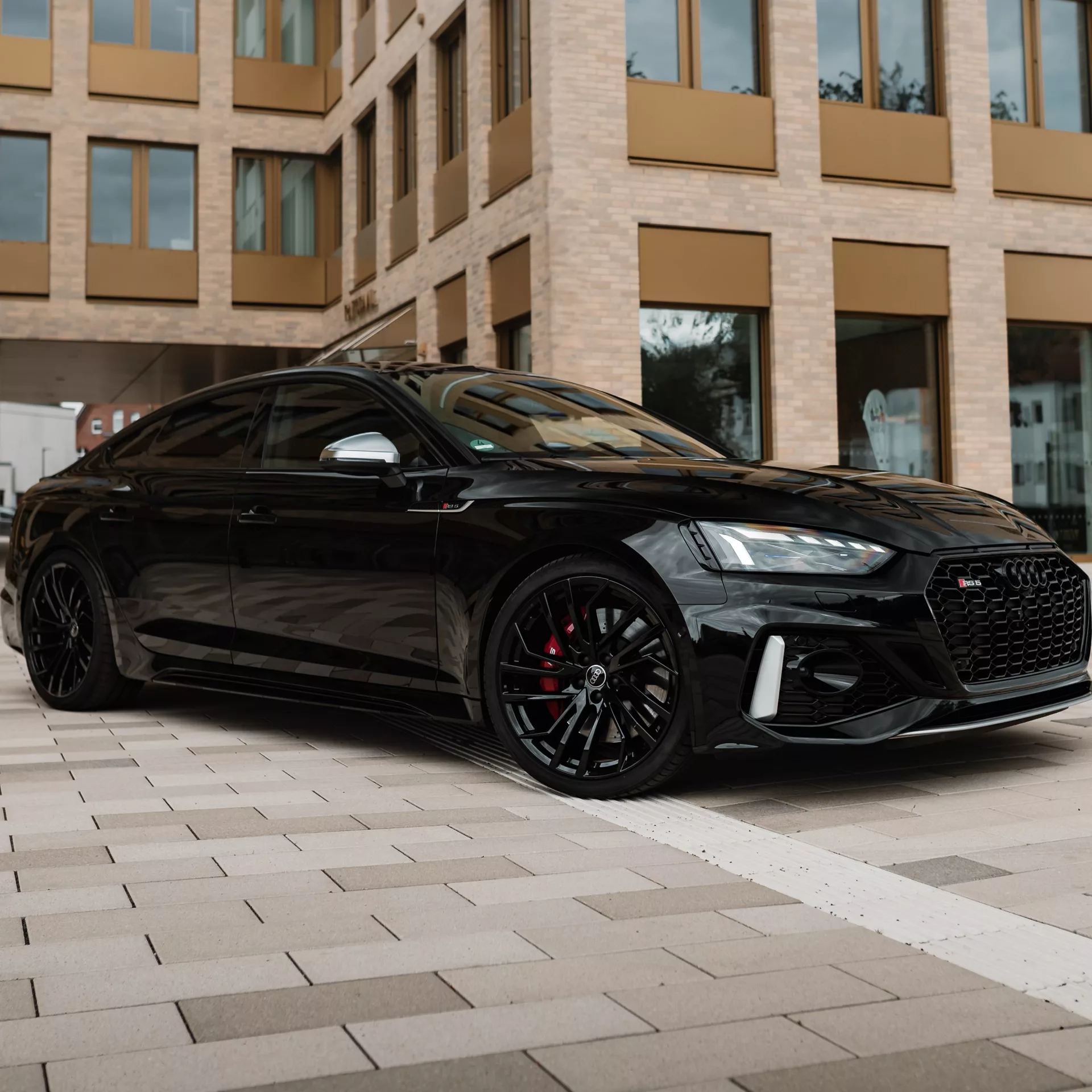 Audi RS5 Sportback in Schwarz, Front- und Seitenansicht mieten