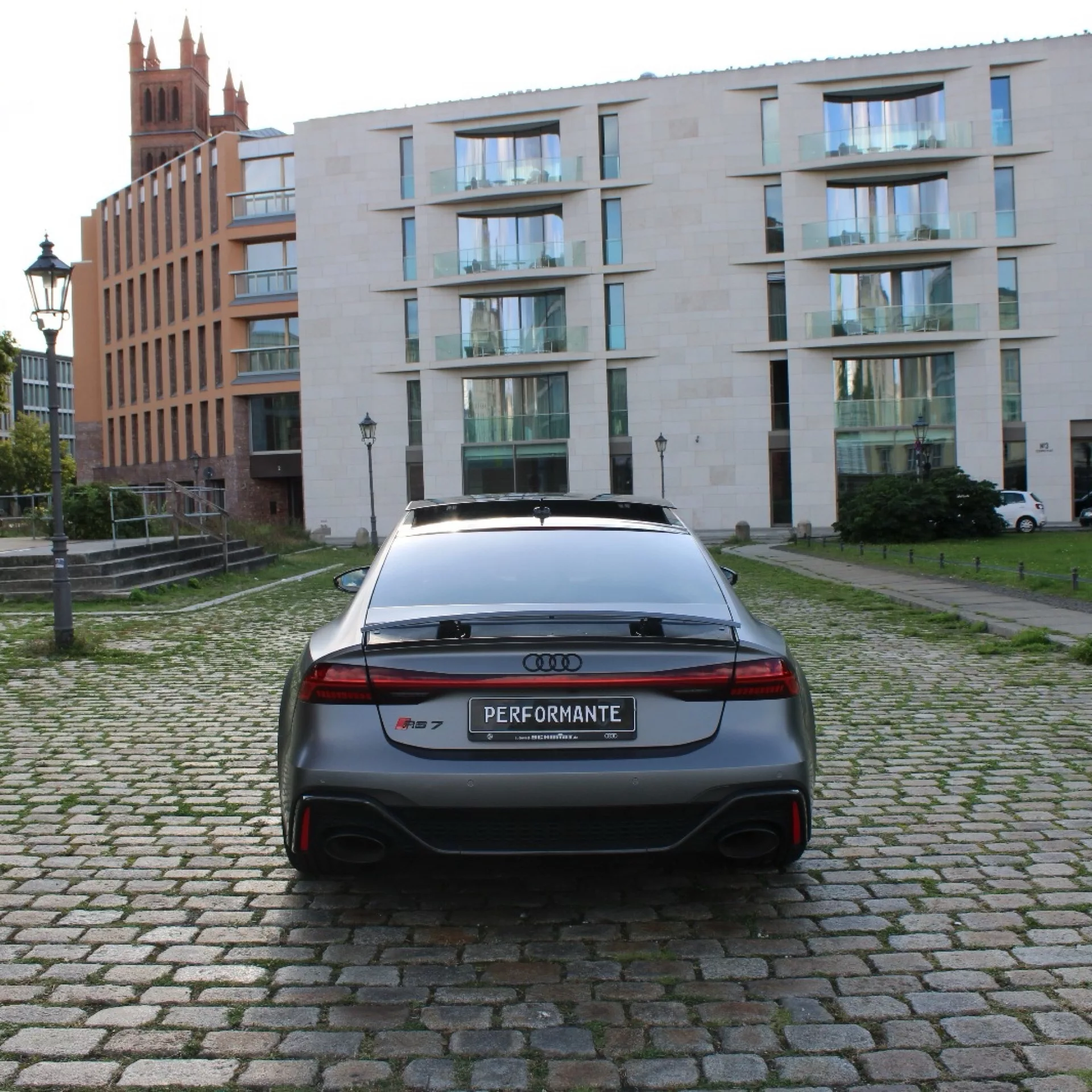Audi RS7 Sportback Heckansicht in Grau vor Gebäuden mieten