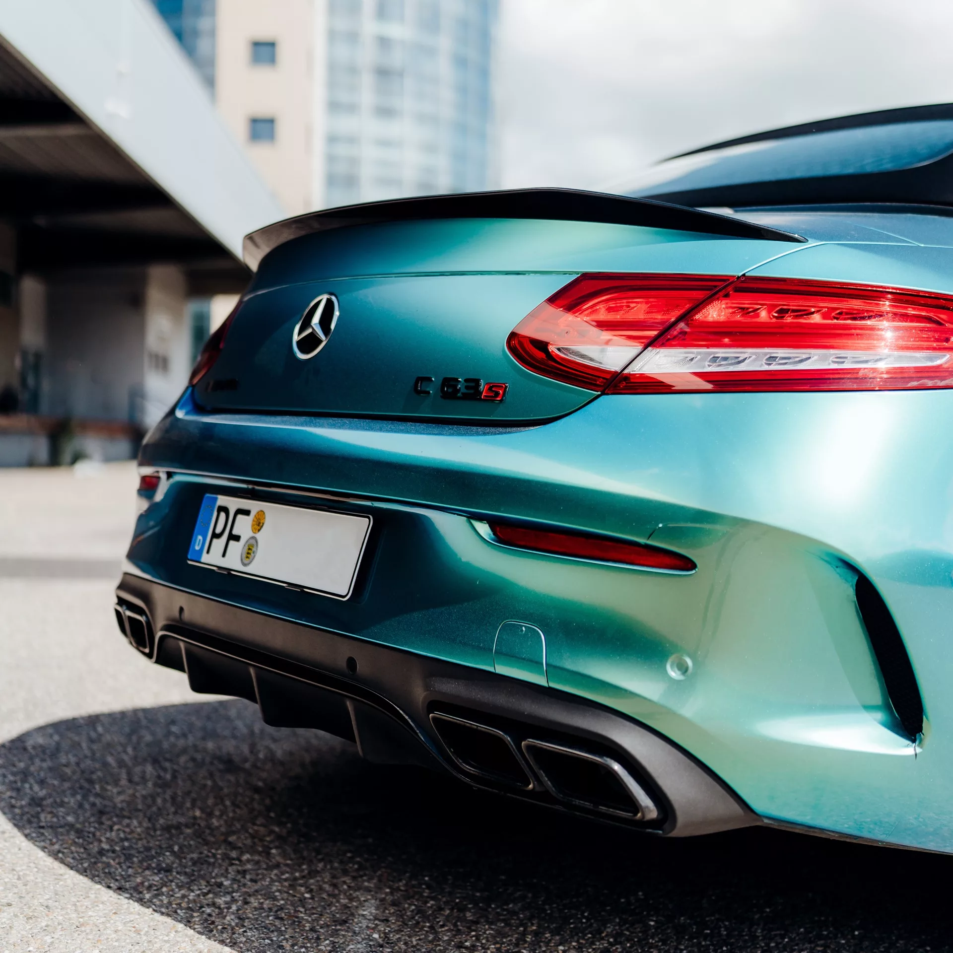 Mercedes C63s Cabrio in Grün von hinten mieten.