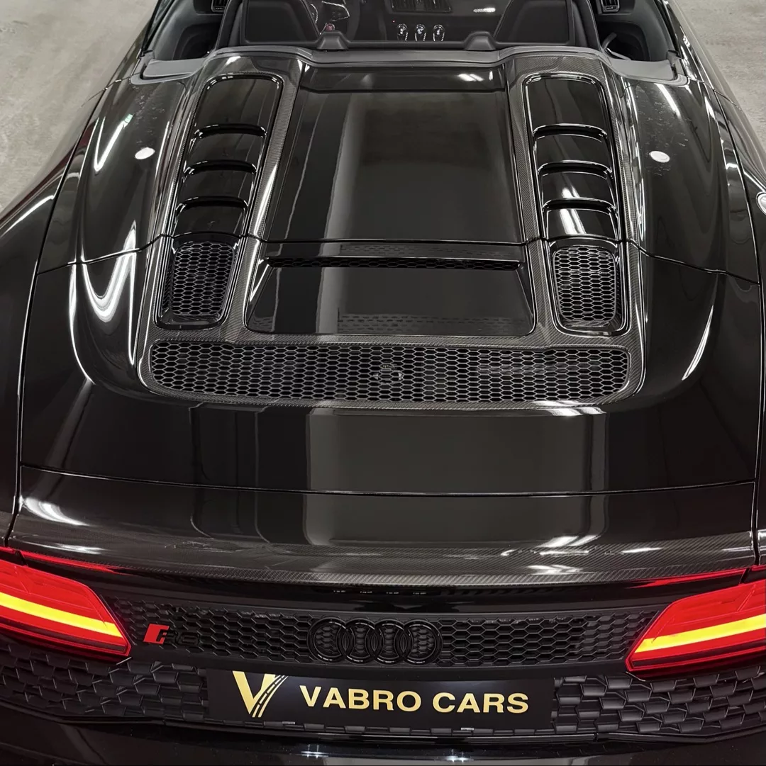 Audi R8 Spyder Performance Heckansicht, schwarz, mit leuchtenden Rücklichtern mieten.