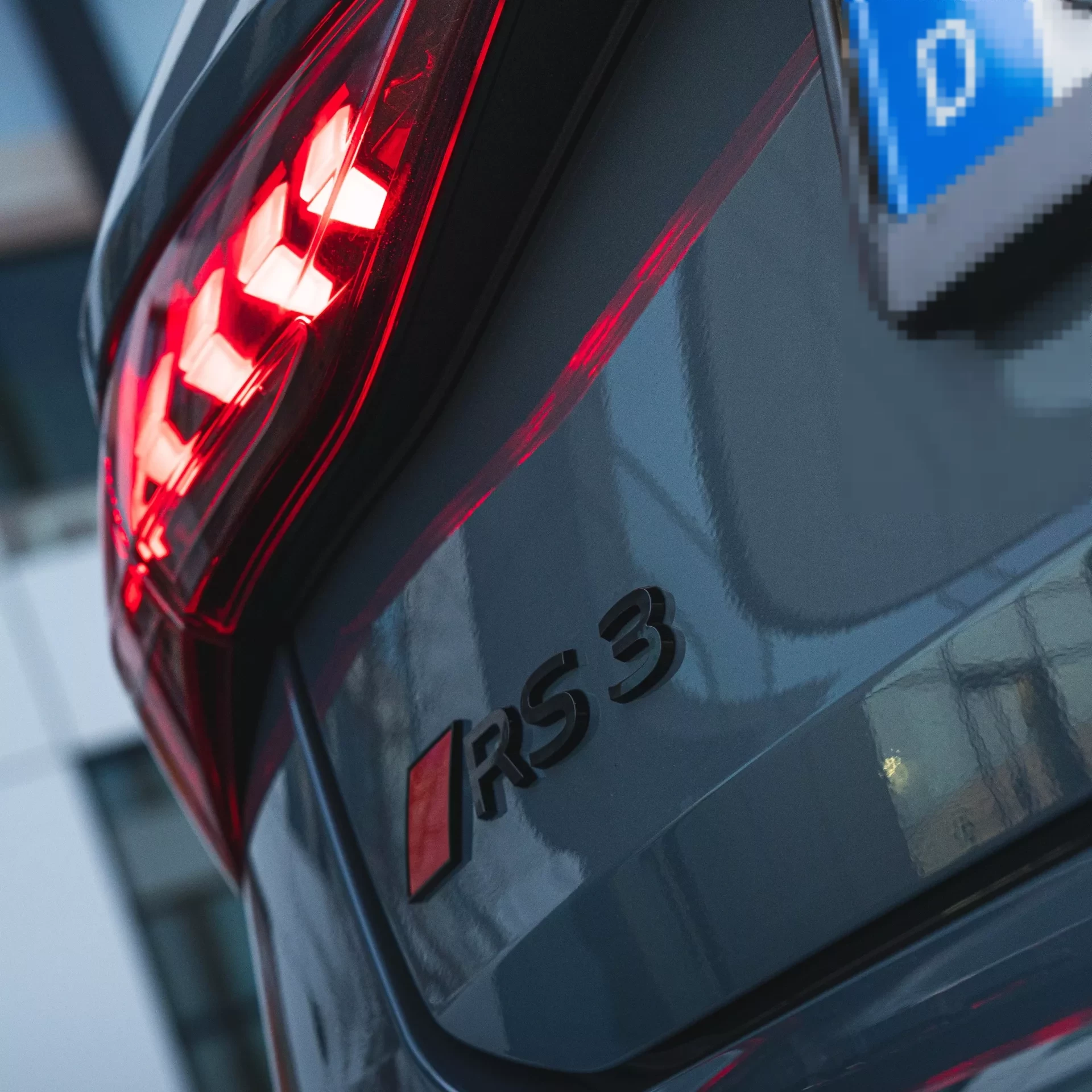 Audi RS3 Sportback Rückansicht in Grau mit leuchtenden Rücklichtern mieten