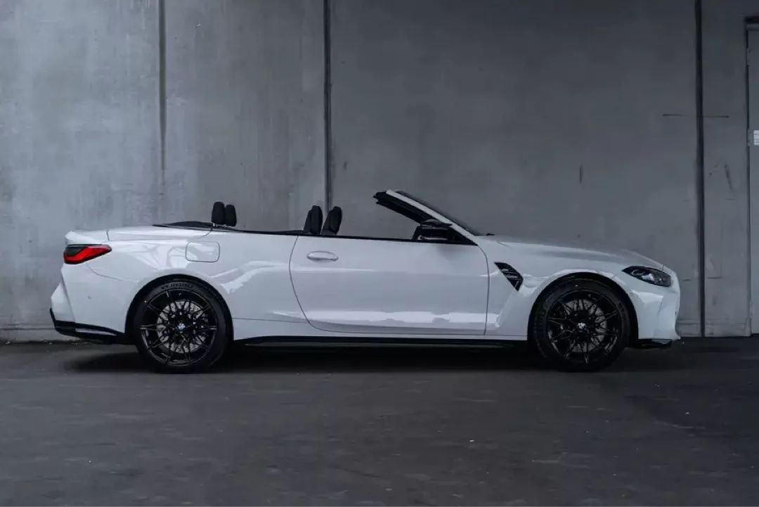 Sportlicher BMW M4 Cabrio Competition in weißer Ausführung, seitlich abgebildet.
