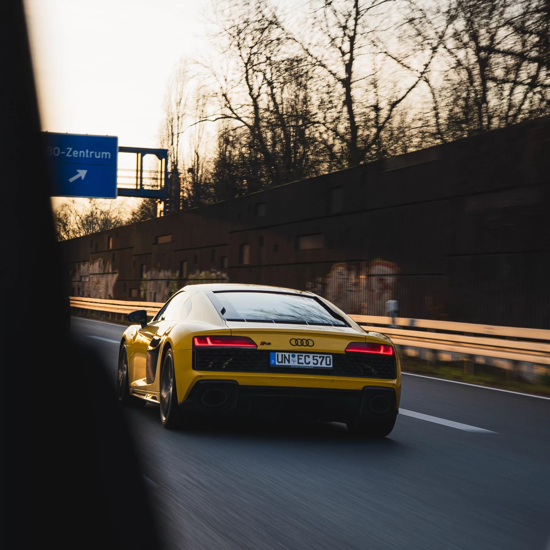 Audi R8 V10 in Gelb auf Autobahn von hinten mieten