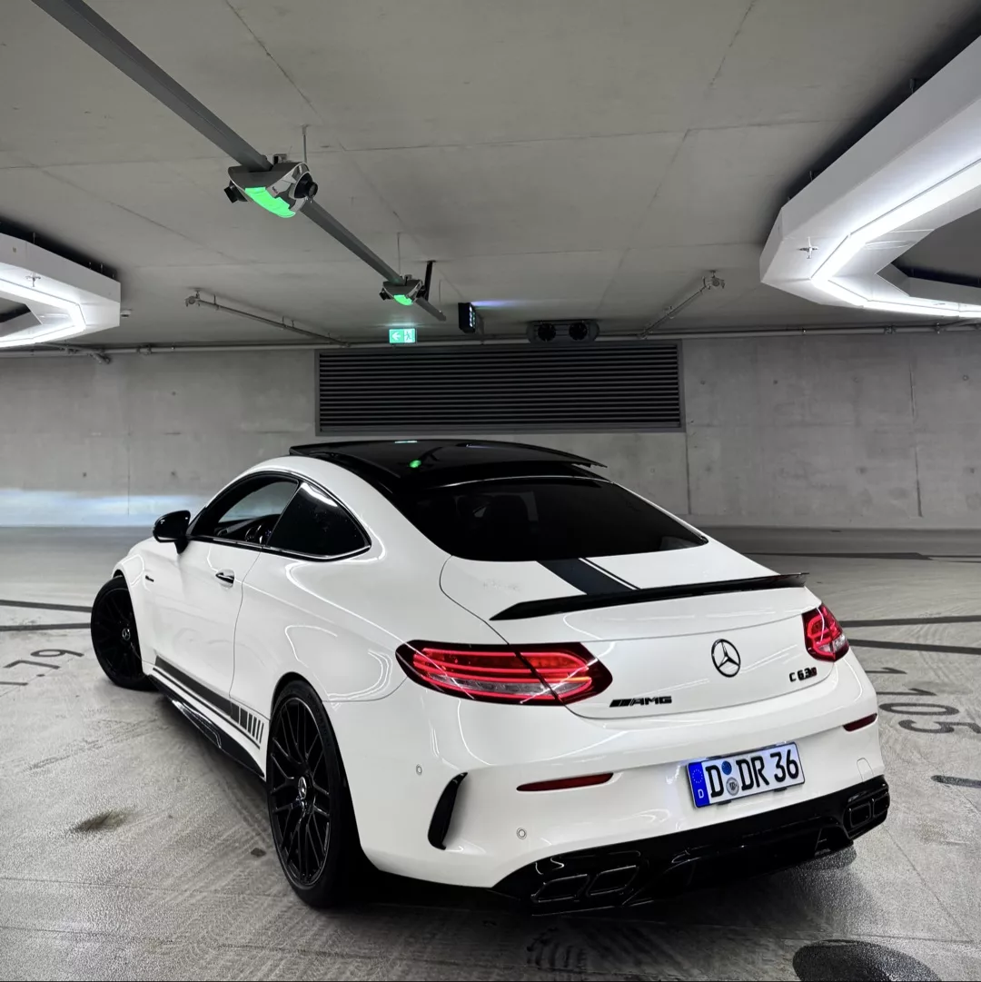 C63s AMG Coupé in Weiß von hinten in Tiefgarage mieten.