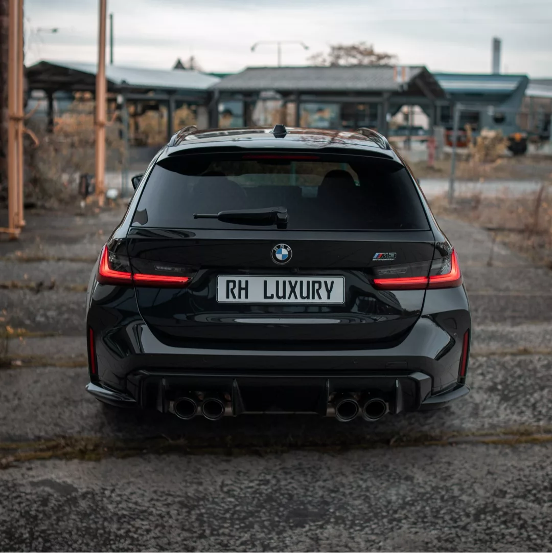 BMW M3 Competition Touring in Schwarz von hinten mieten.