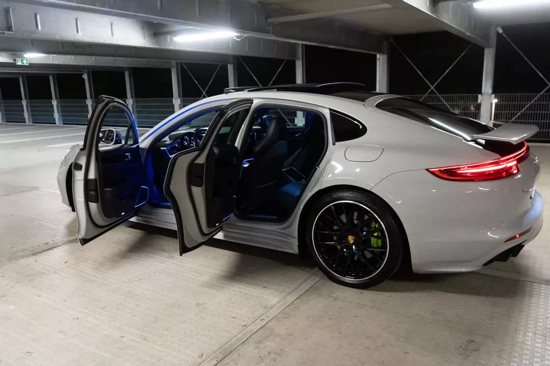 Porsche Panamera in Weiß mit offenen Türen von der Seite mieten.
