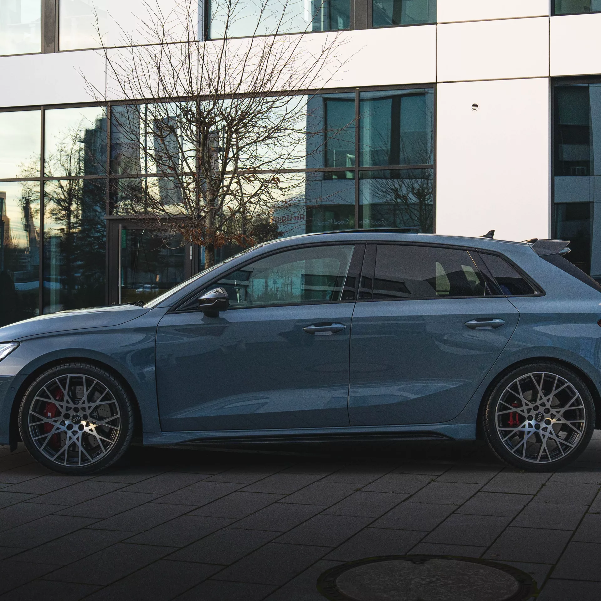 Audi RS3 Sportback in Blau von der Seite mieten.