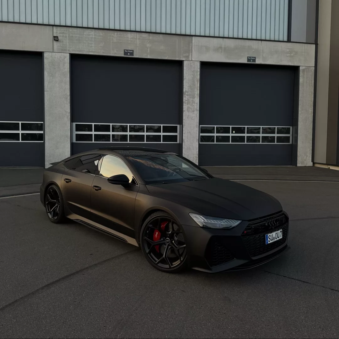 Audi RS7 Performance in Mattschwarz vor Garage mieten.