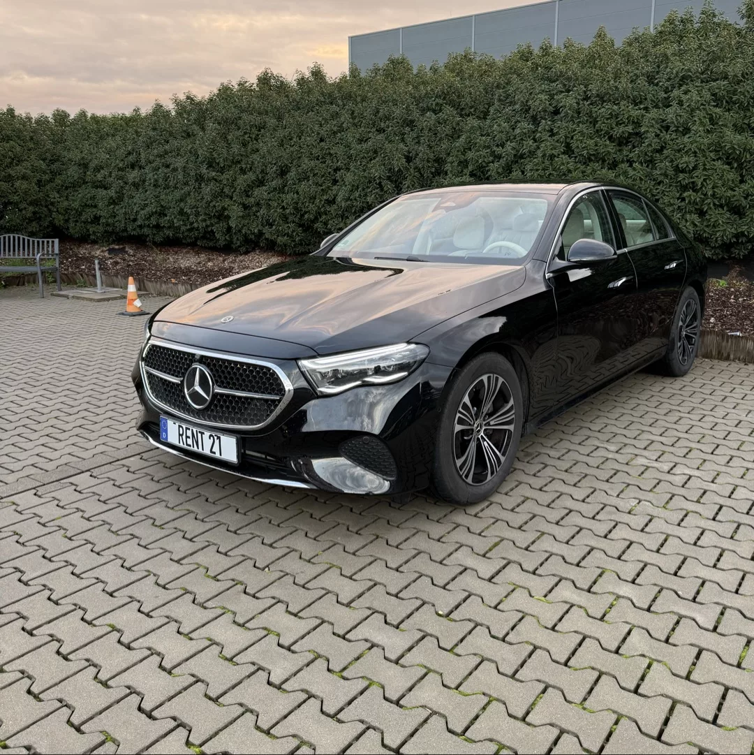 Mercedes-Benz E200 4MATIC in Schwarz, Frontansicht, auf Parkplatz mieten.