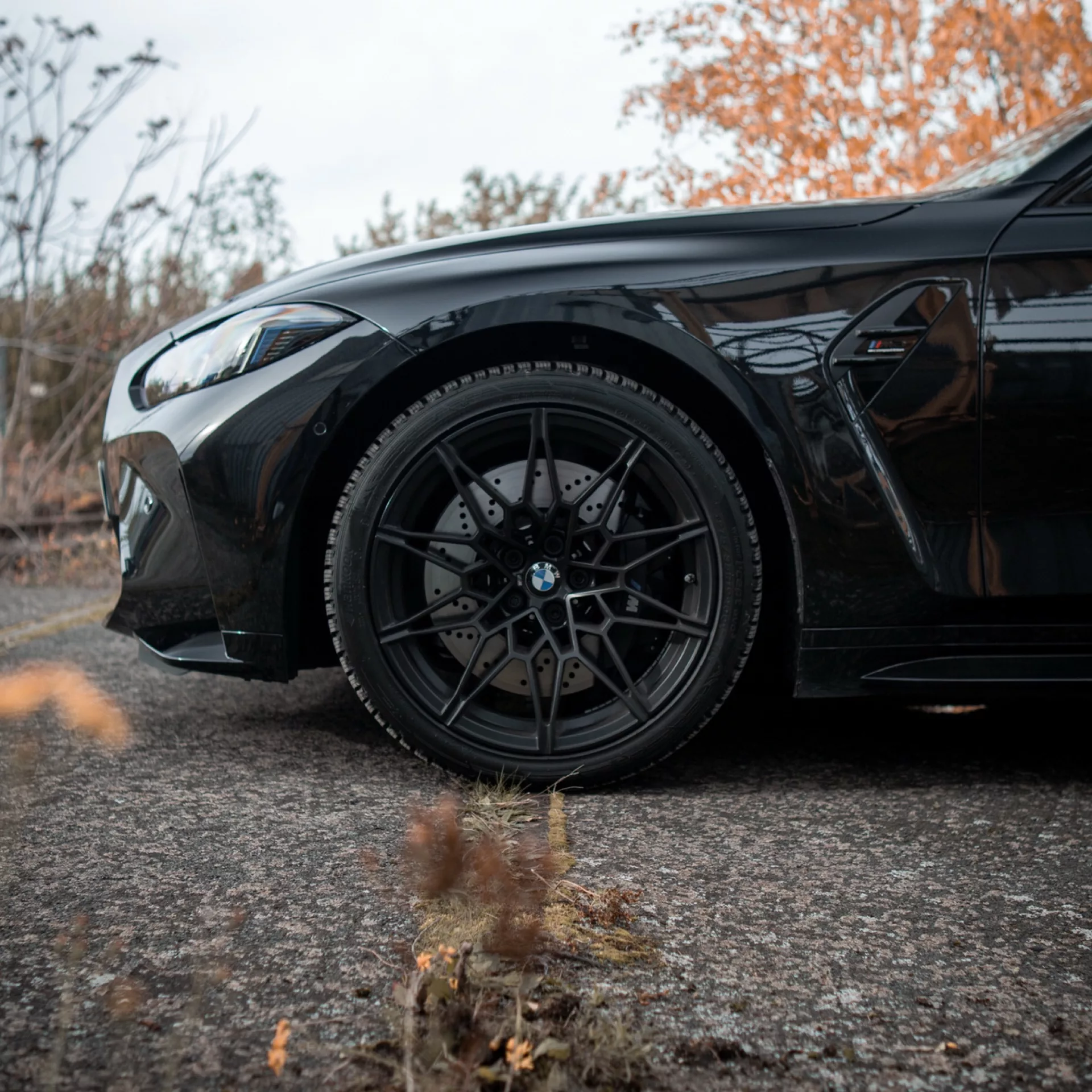 BMW M3 Competition Touring in Schwarz mieten - Seitenansicht mit Fokus auf Reifen.