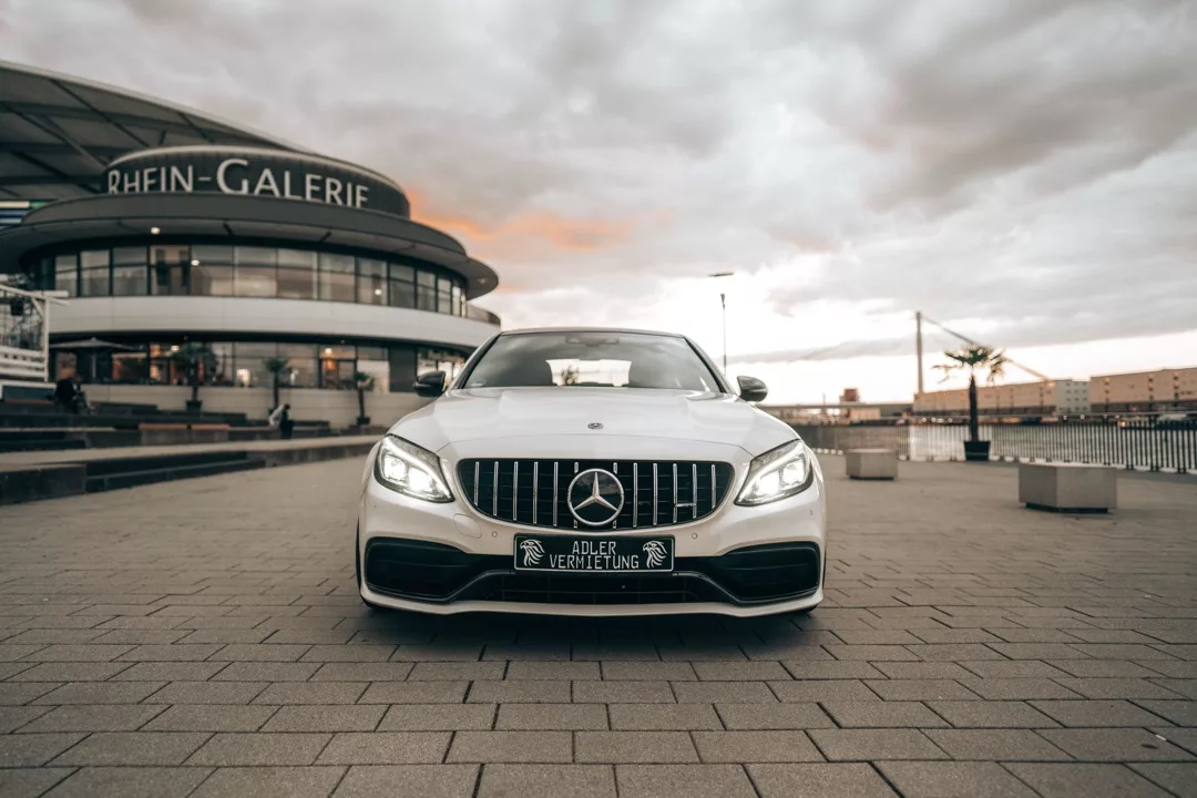 Mercedes C63 AMG in Weiß, Frontansicht vor Rhein-Galerie mieten.