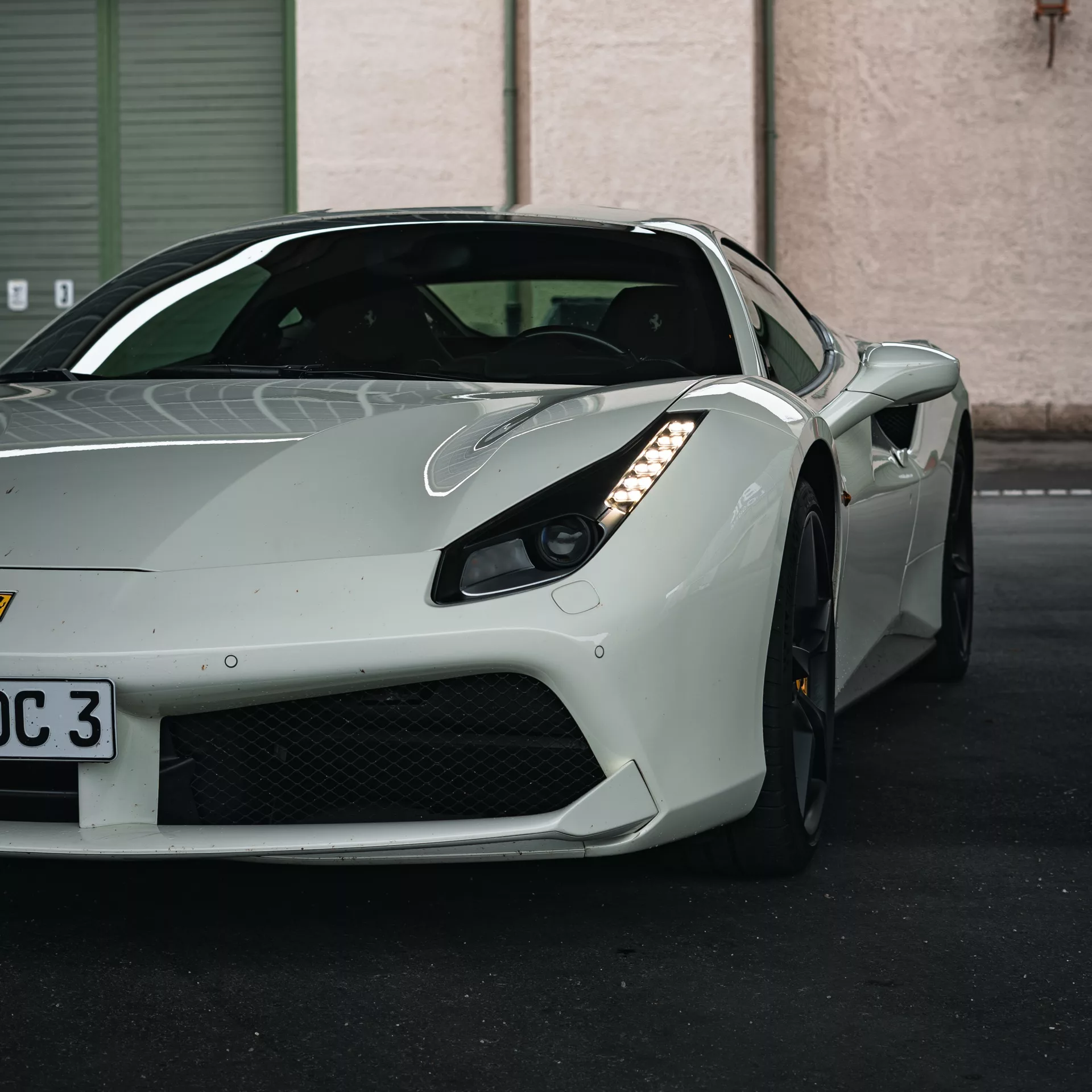 Ferrari 488 GTB in Weiß mieten - Vorderansicht auf Parkplatz