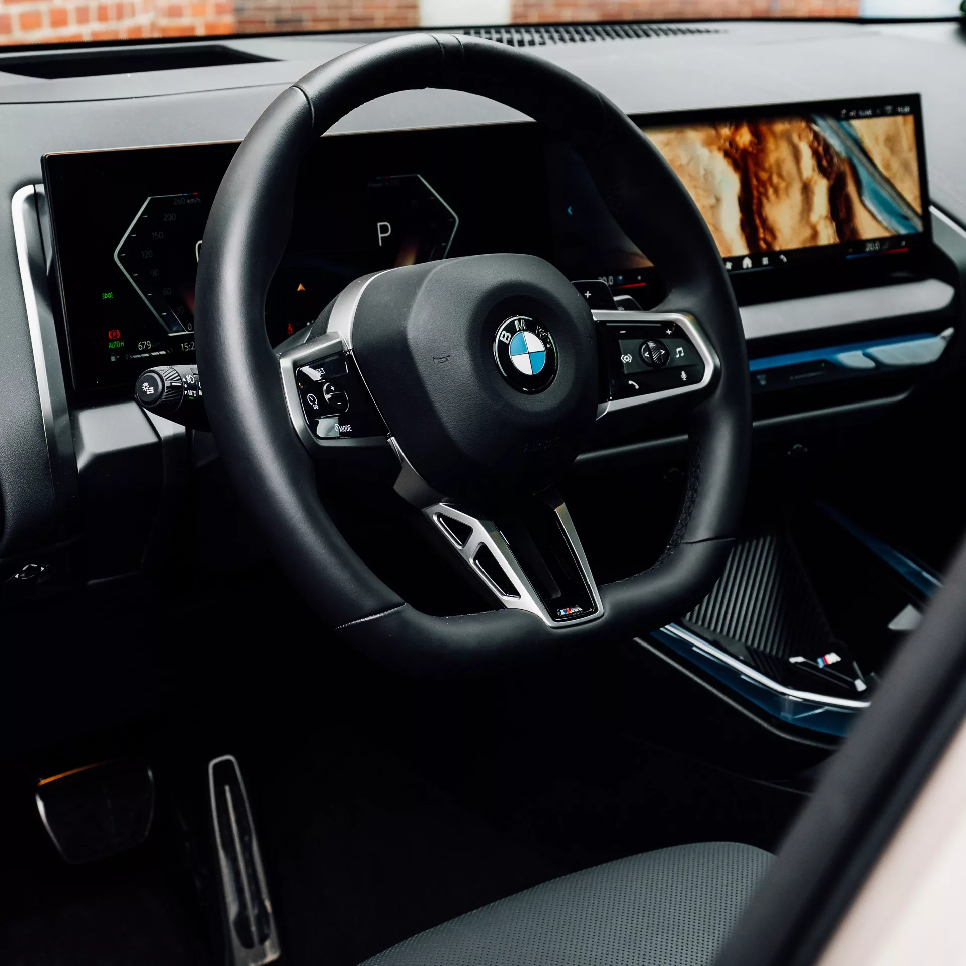 BMW X3 Innenraum in Dune Grey mit Lenkrad und Displays mieten.