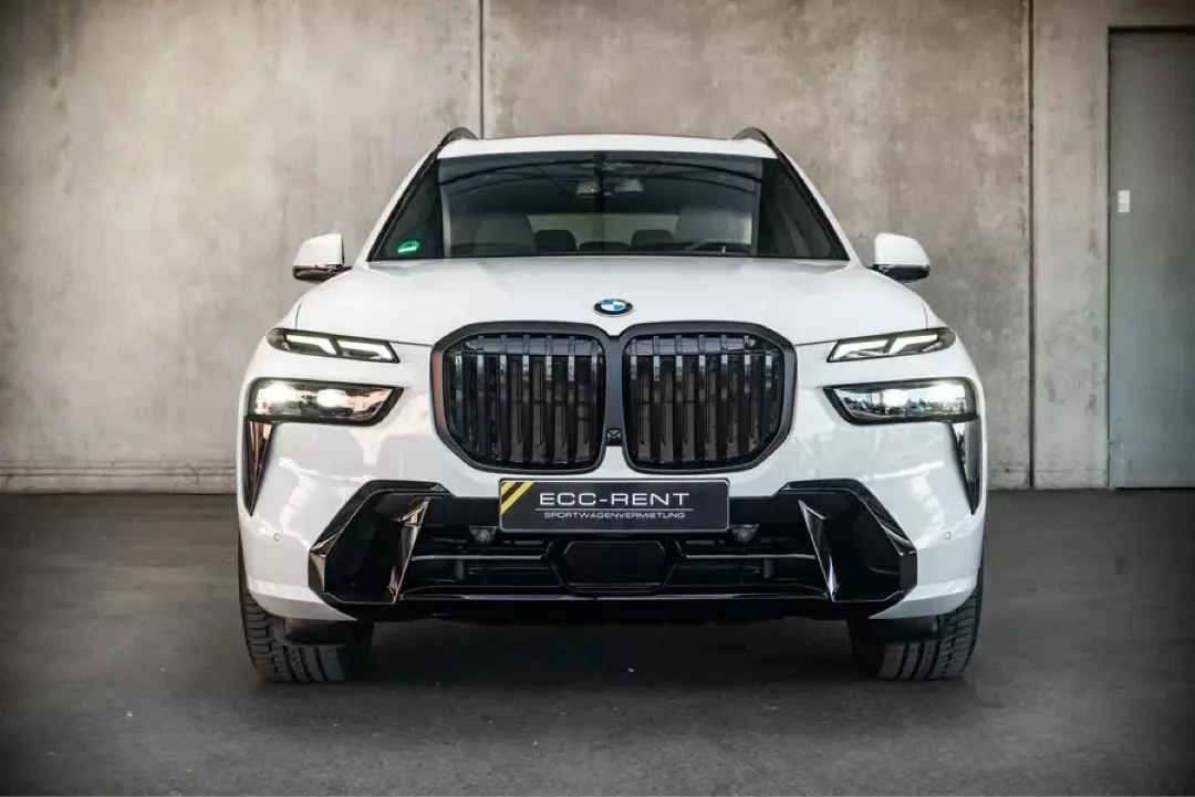 Weißer BMW X7 vor grauer Wand auf Vermietungsplattform.