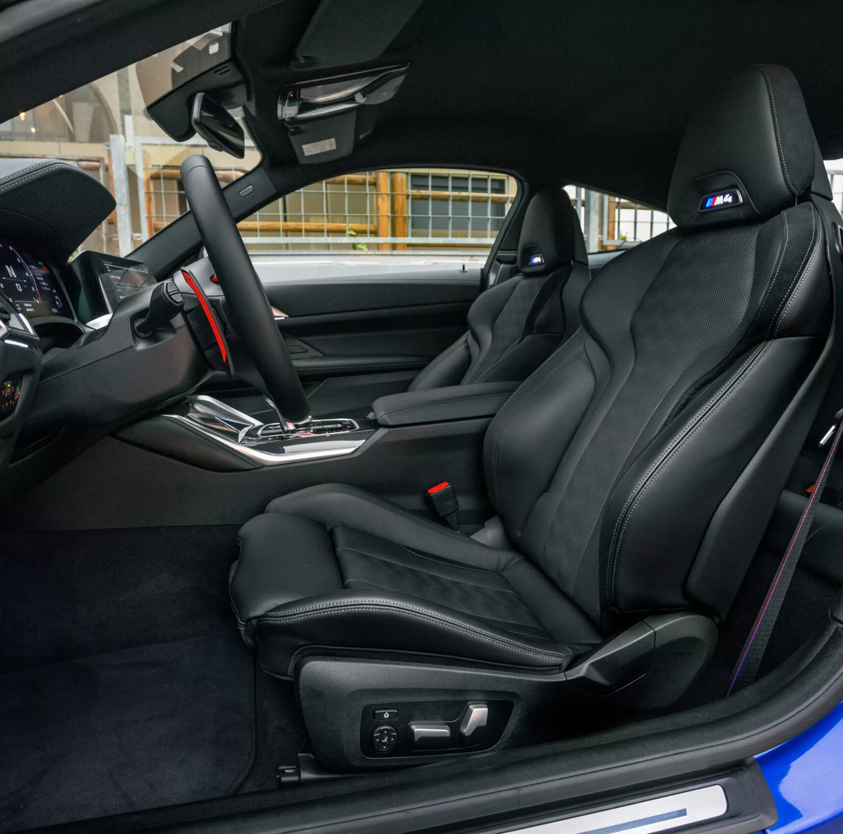 Innenraum eines BMW M4 Competition mit schwarzen Ledersitzen.