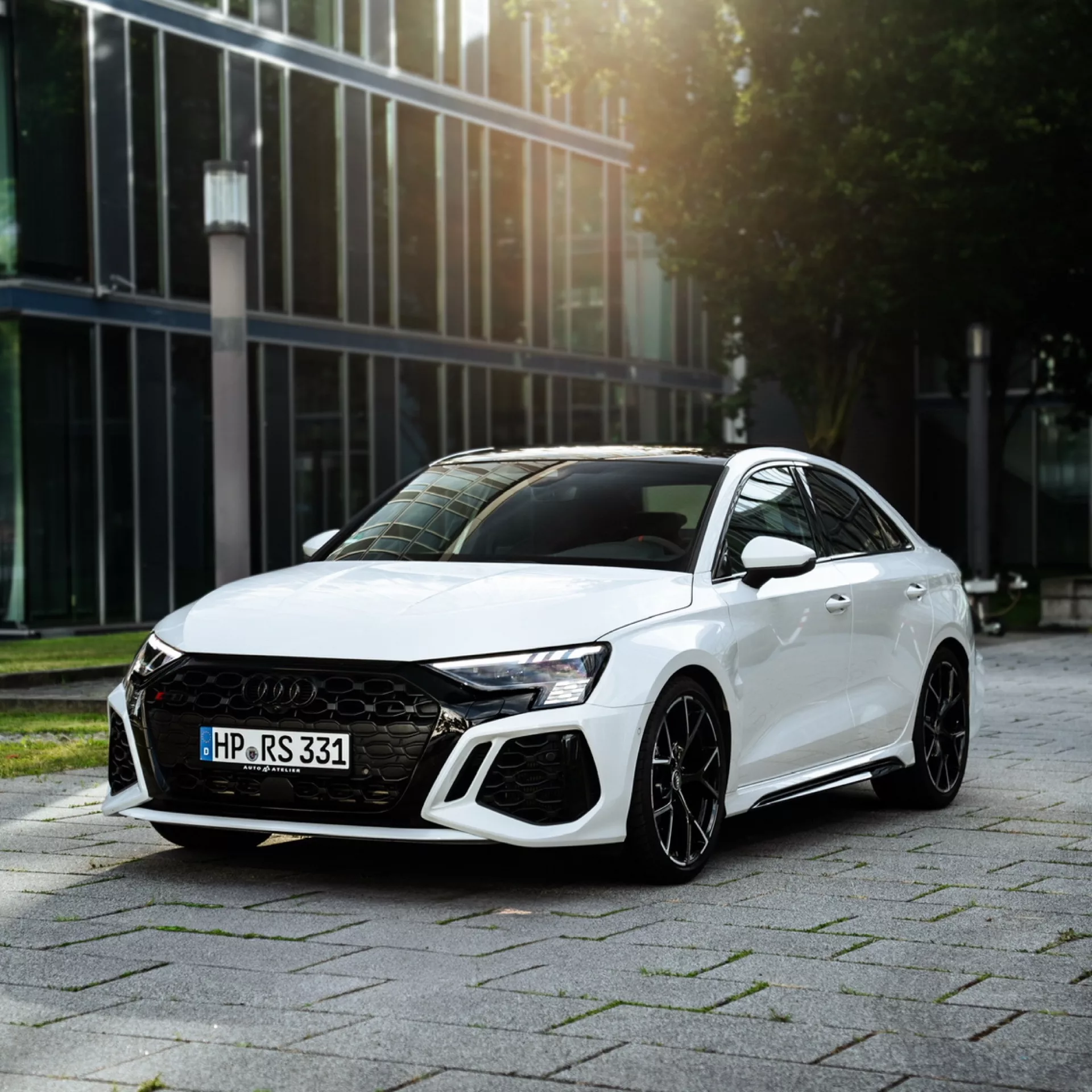Audi RS3 Limousine in Weiß, Frontansicht vor Bürogebäude mieten.