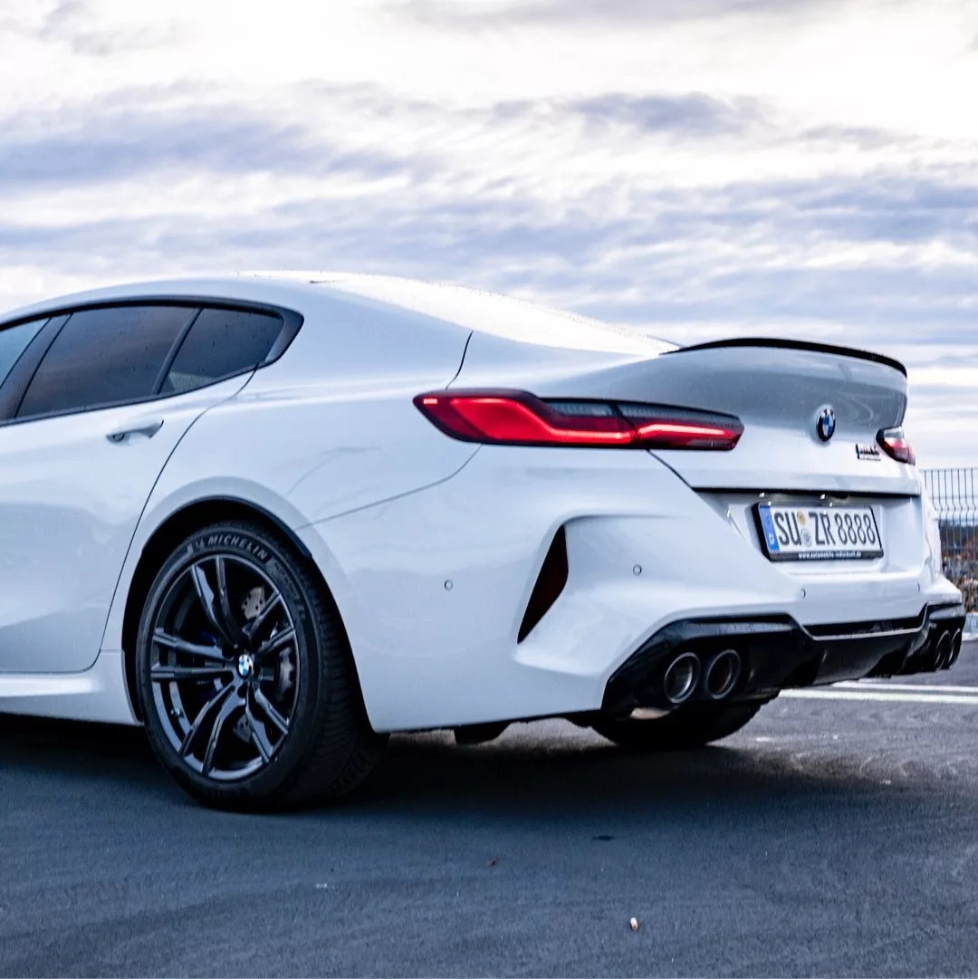 BMW M8 CS Gran Coupe in Weiß von schräg hinten mieten.