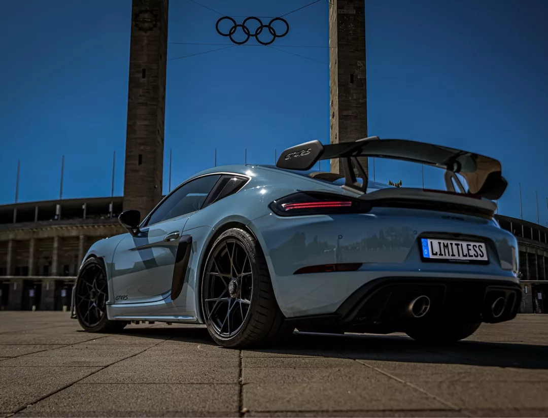 Porsche 718 GT4 RS in Blau, Heckansicht vor Monument mieten