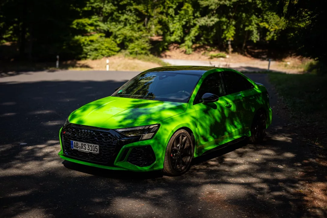 Audi RS3 Limousine in Grün auf Waldstraße mieten