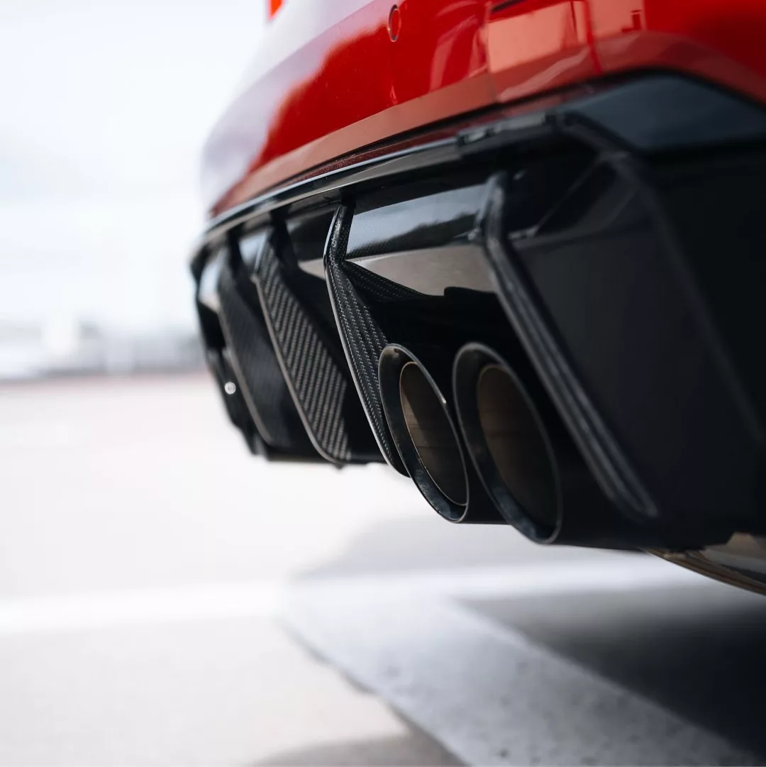 Roter BMW M4 Competition xDrive mit markantem Vierfach-Auspuff.