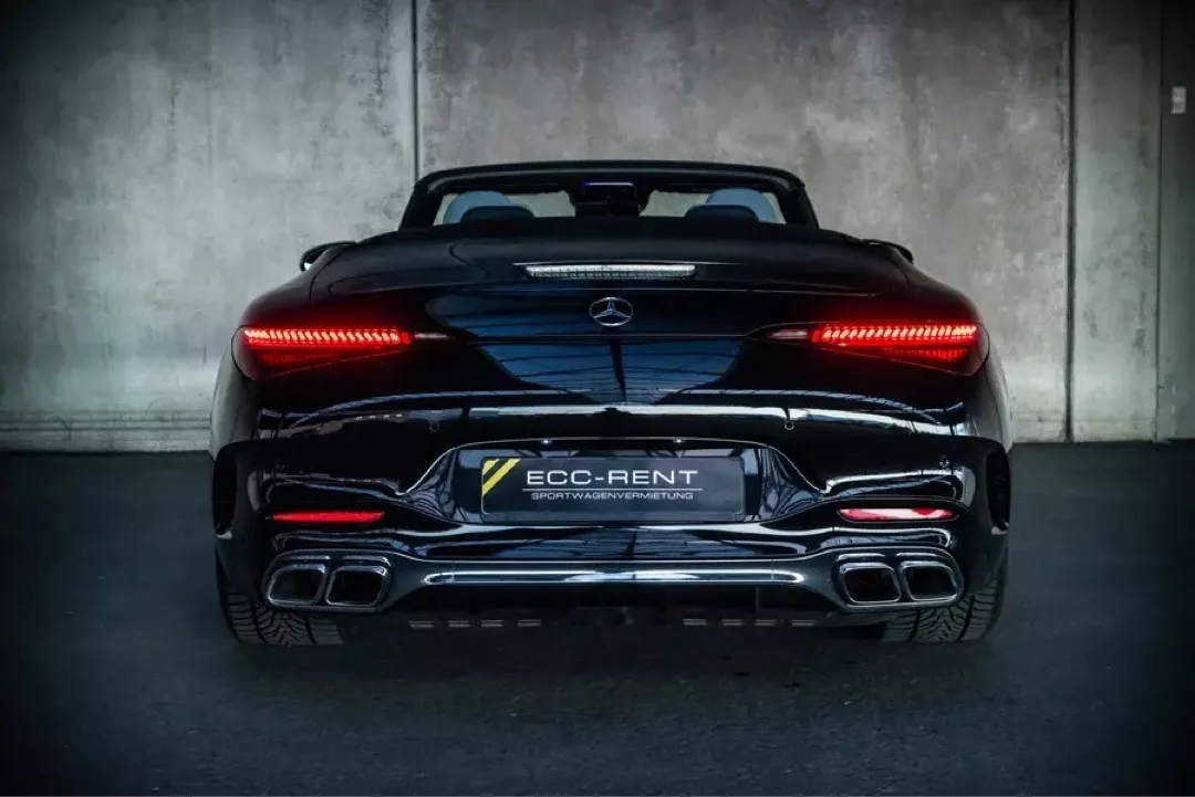 Luxuriöser schwarzer Mercedes-Benz SL63 AMG Roadster von hinten in einer Garagenumgebung.