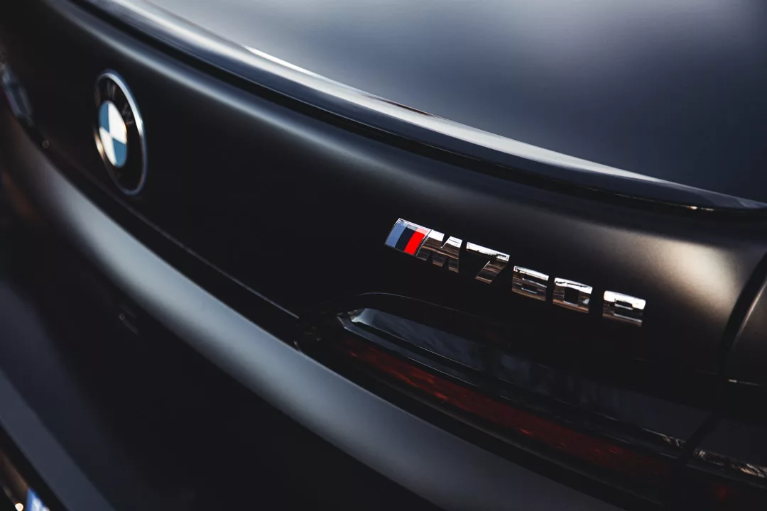 BMW M760e Heckemblem aus der Nähe mieten.