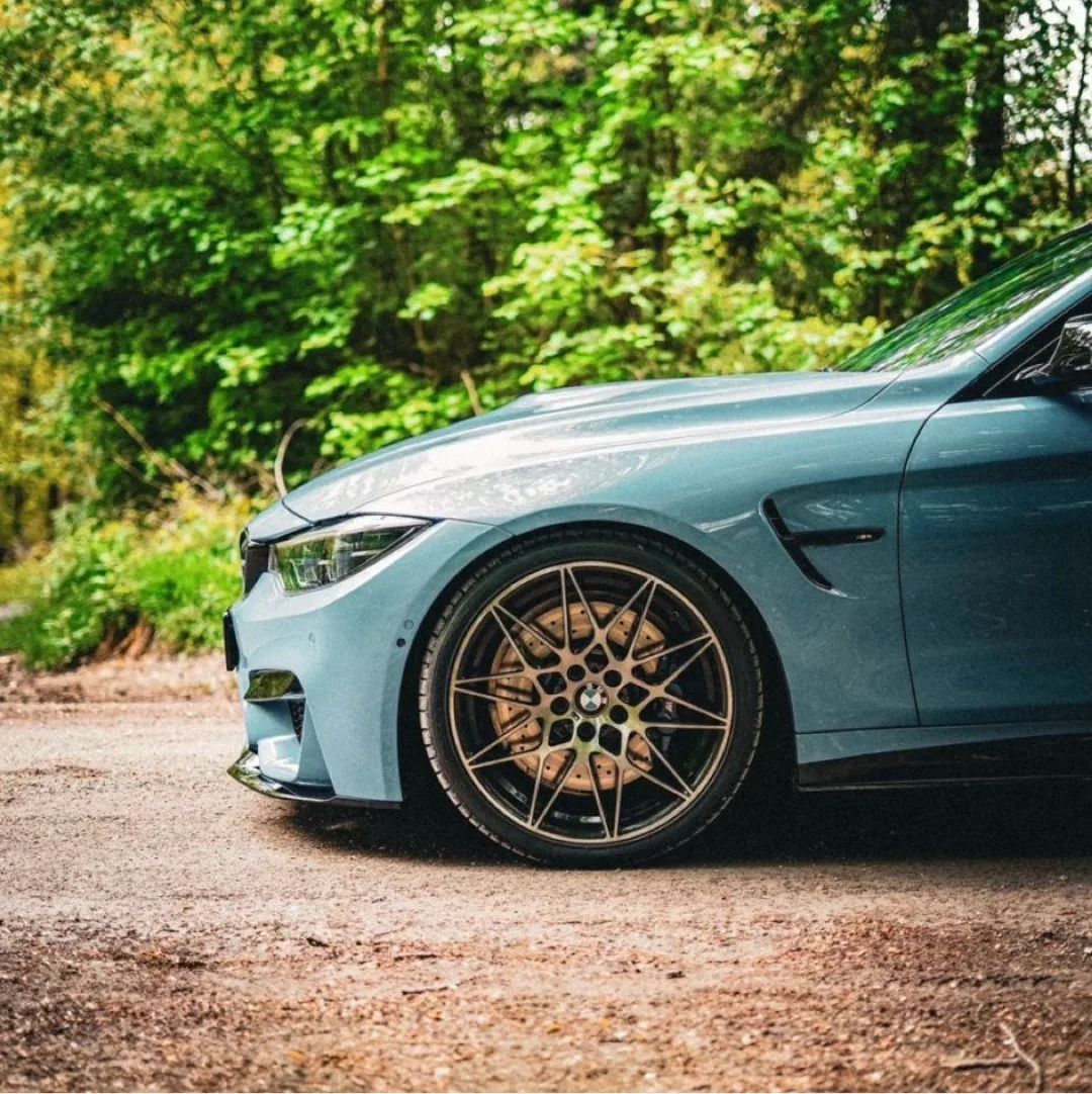 BMW M4 Competition in Blau von der Seite mieten.