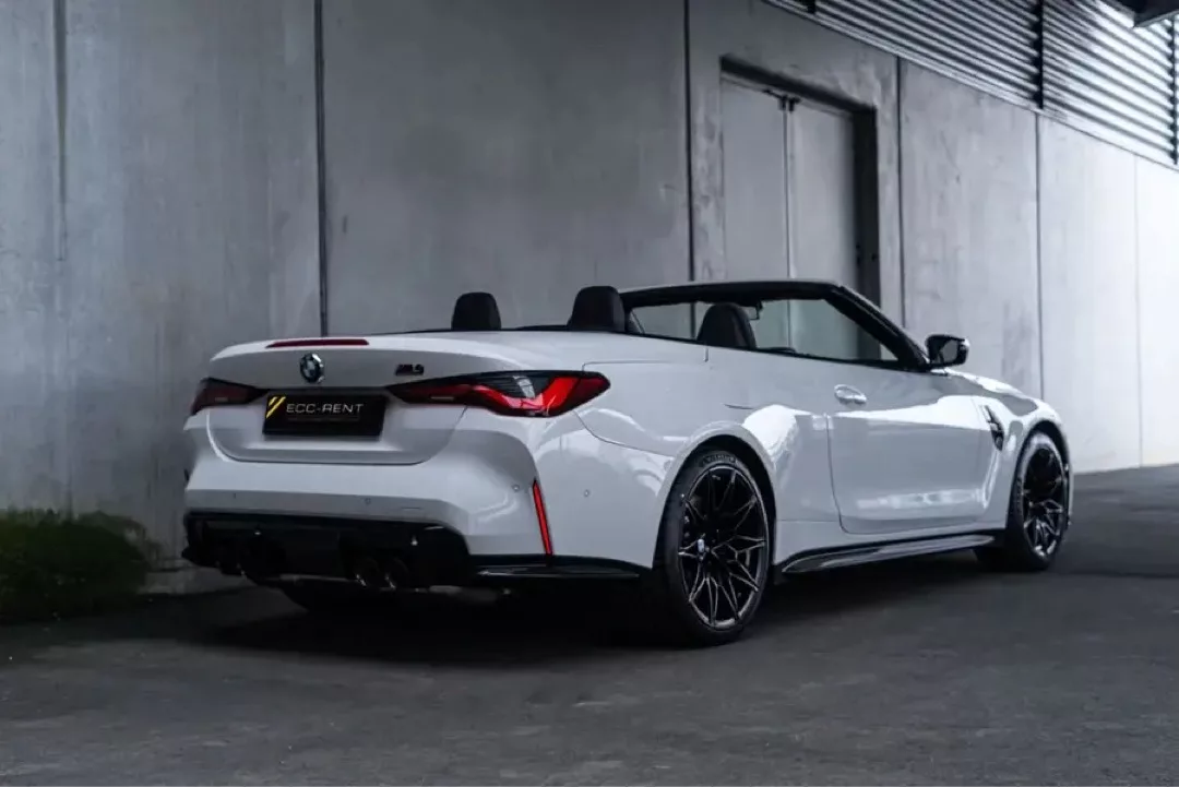 Weißes BMW M4 Cabrio Competition in Garageneinfahrt.