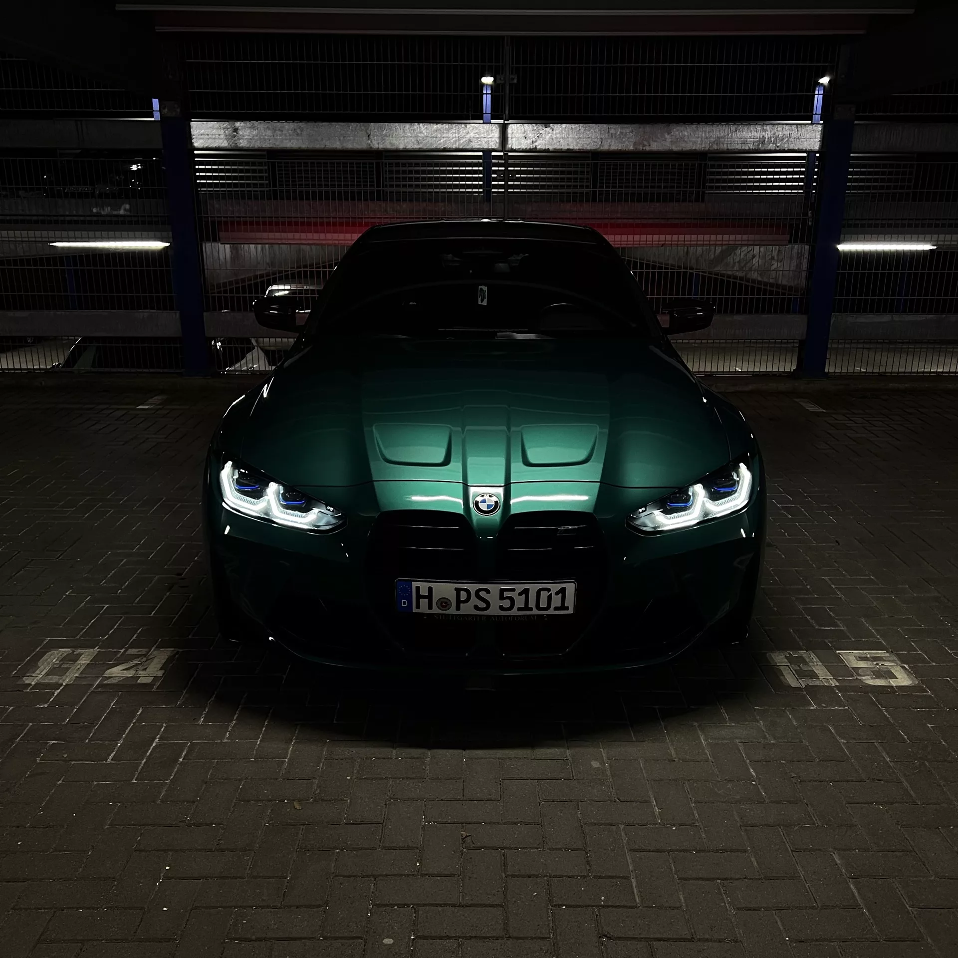 BMW M4 Competition in Grün, Frontansicht bei Nacht mieten.