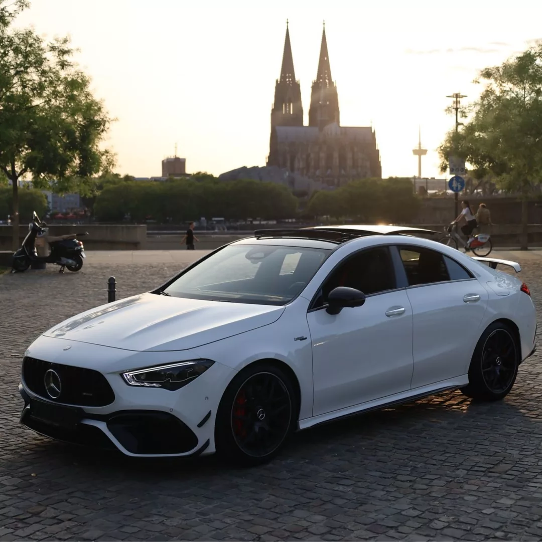Mercedes AMG CLA45s 4M+ geparkt vor einer Kathedrale im Abendlicht.