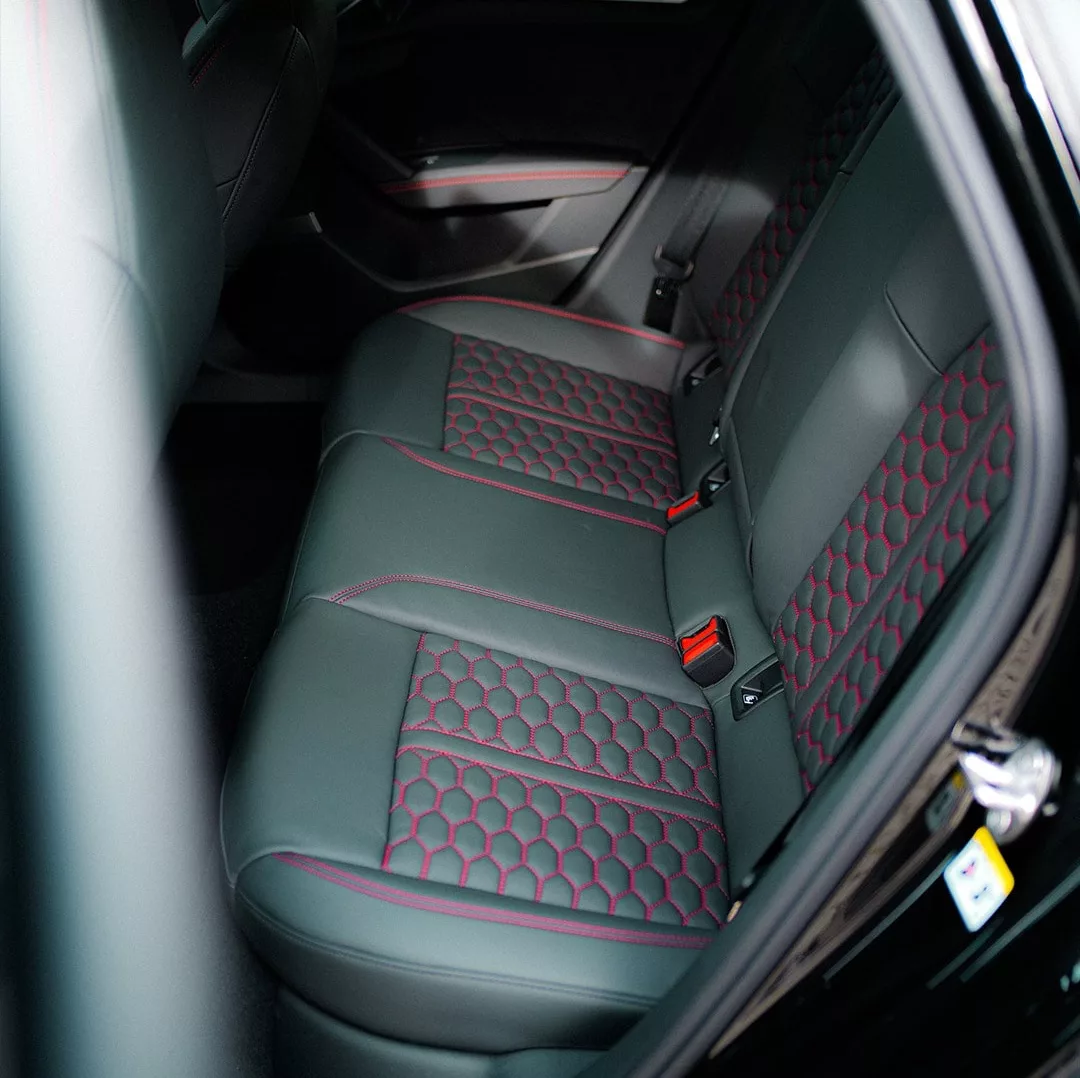 Audi RS3 Rücksitze mit schwarzem Leder und roten Nähten mieten.