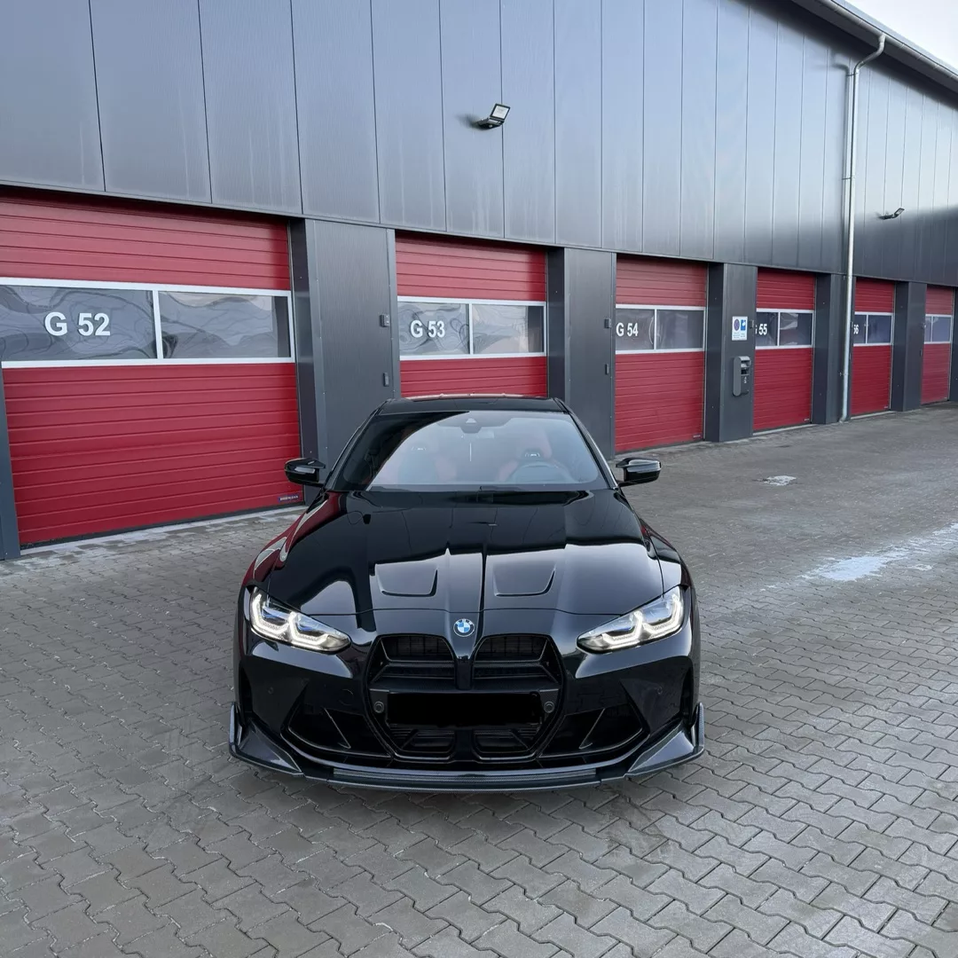 BMW M4 Competition XDrive in Schwarz vor Garage mieten.