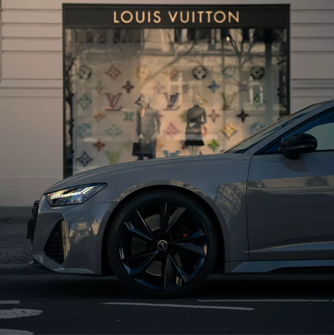 Audi RS6 Avant in Grau, Seitenansicht vor Geschäft mieten.