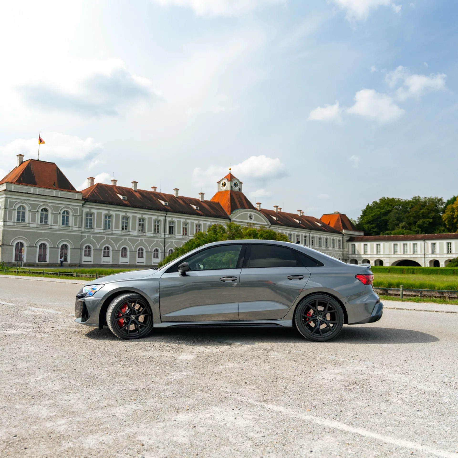 Audi RS3 FACELIFT in Grau von der Seite vor Schloss mieten.