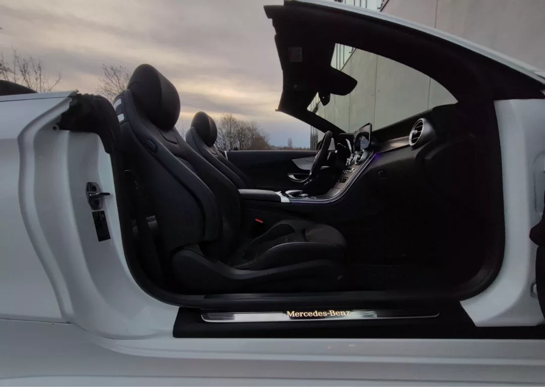 Mercedes C180 Cabrio AMG-Line Sport in Weiß, Innenansicht mit offenem Verdeck mieten.