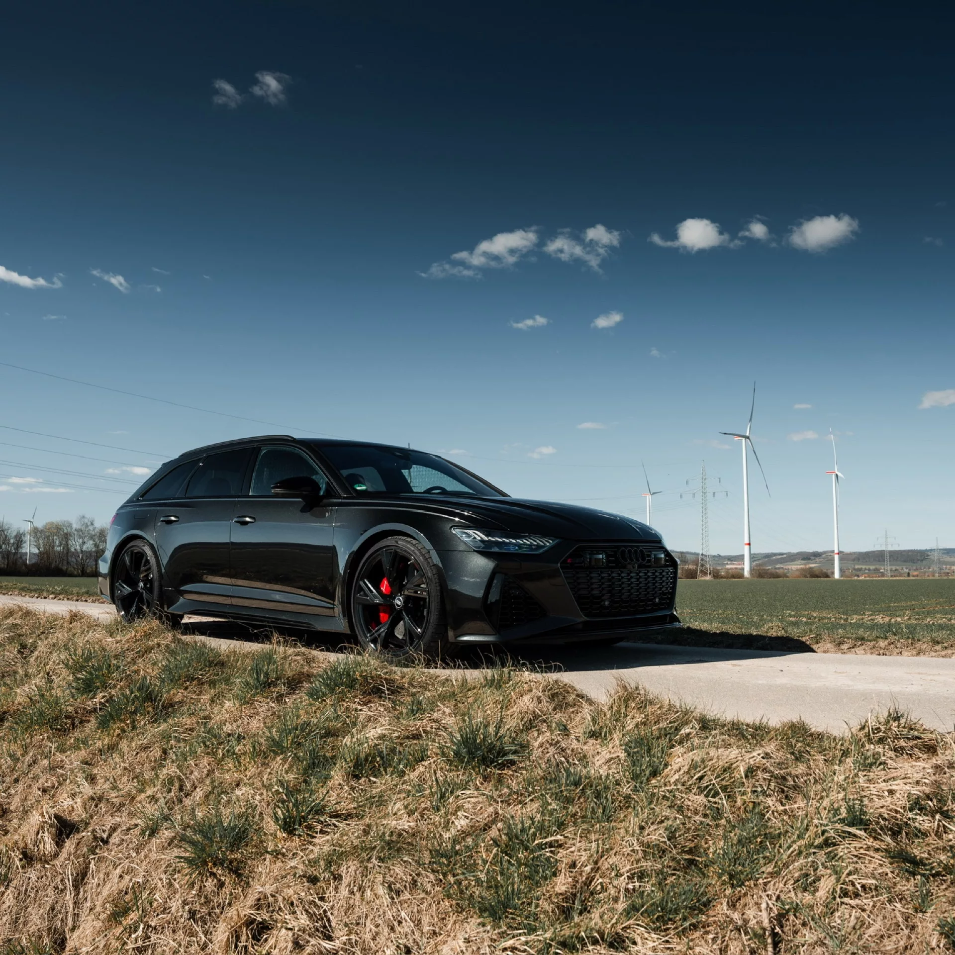 Audi RS6 in Schwarz vor Windrädern mieten.