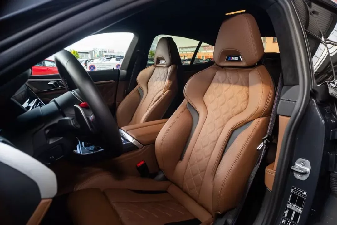 Luxuriöser Innenraum des BMW M8 Gran Coupé mit braunen Sportsitzen.