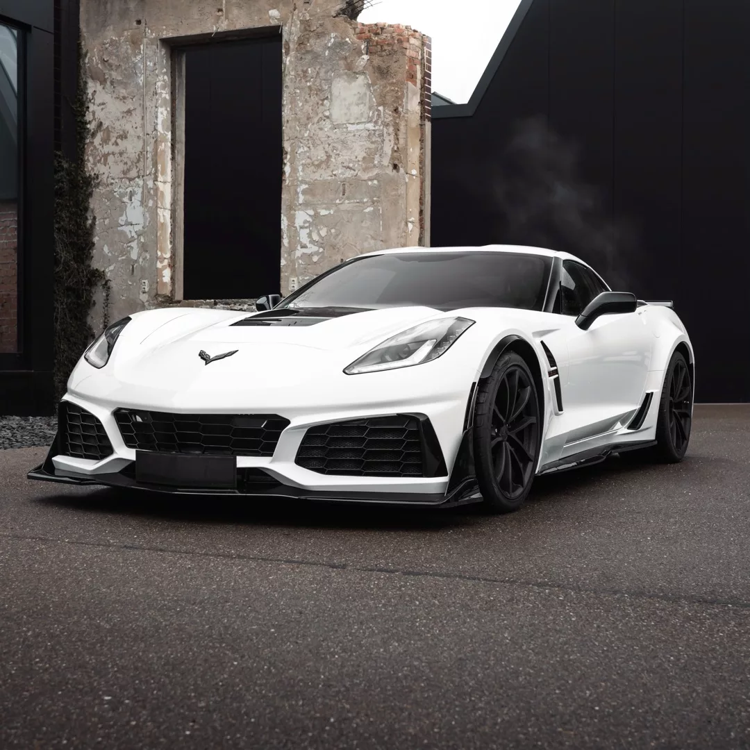 Corvette C7 Grand Sport ZR1 in Weiß mieten - Frontansicht vor Industriegebäude.