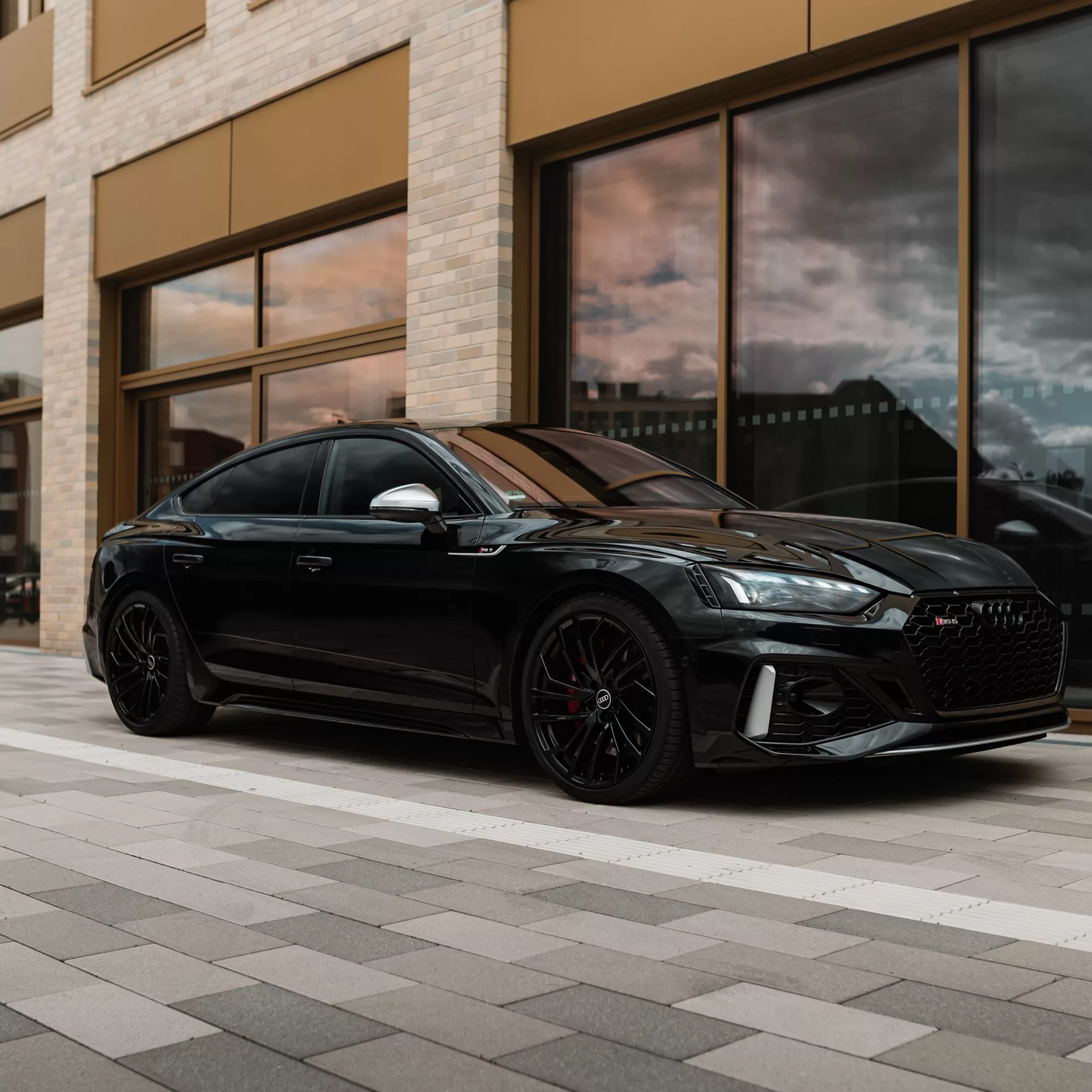 Audi RS5 Sportback in Schwarz, Seitenansicht vor Gebäude mieten