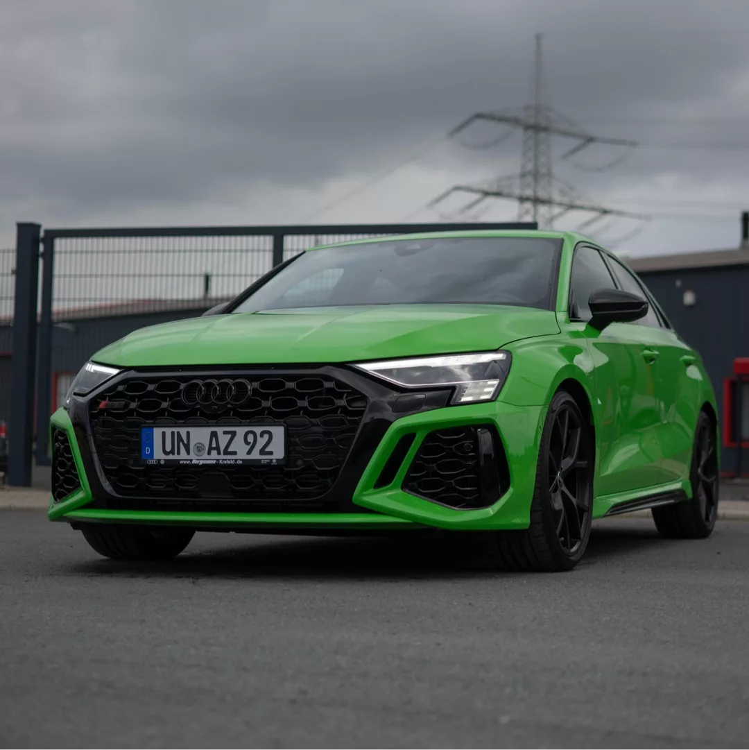 Audi RS3 Performance 8Y in Grün, Frontansicht auf Parkplatz, mieten.