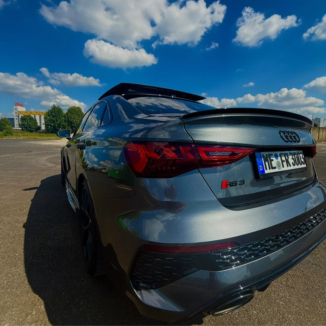 Audi RS3 Limousine in Grau von hinten mieten.