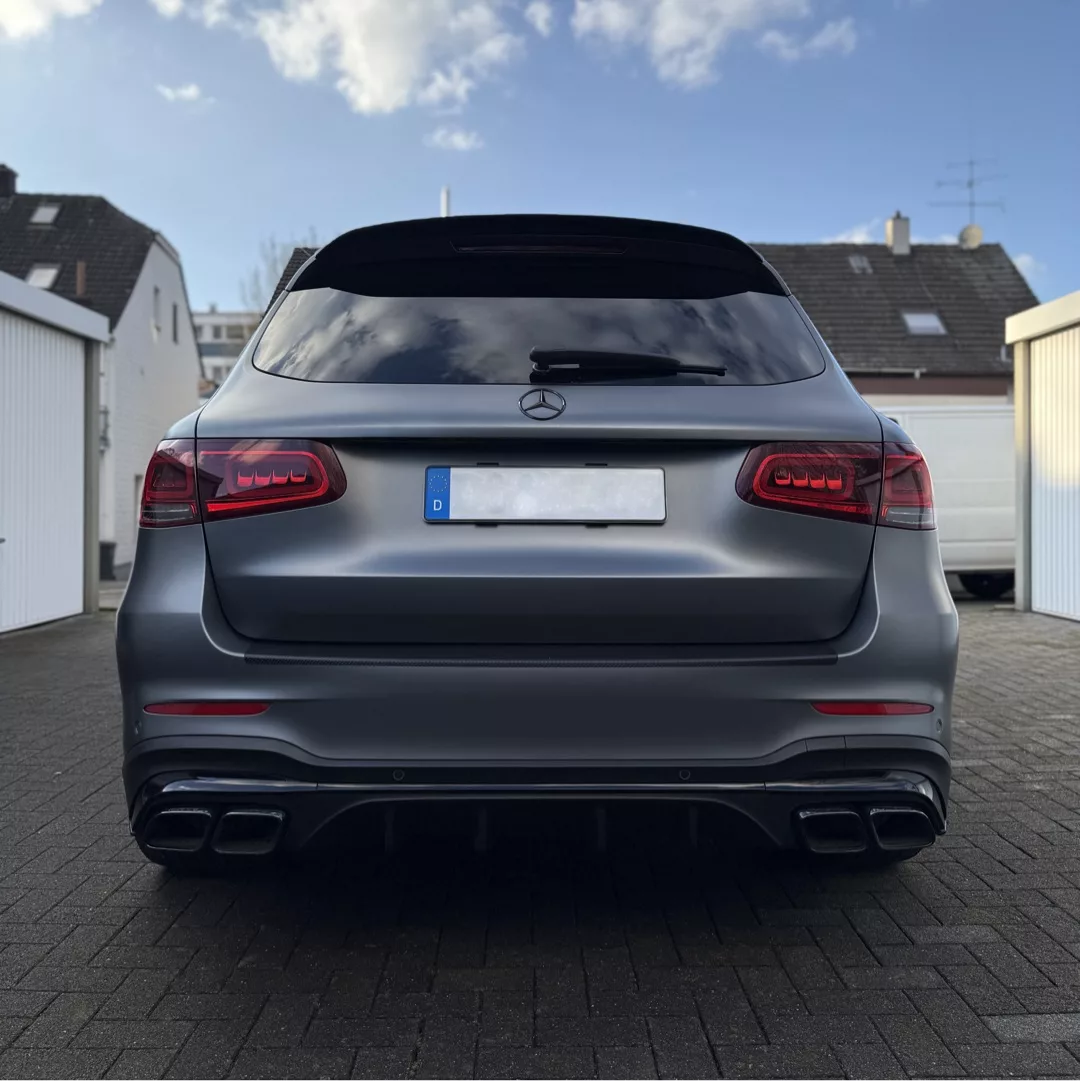 Mercedes-Benz GLC63AMG Facelift in Grau von hinten mieten