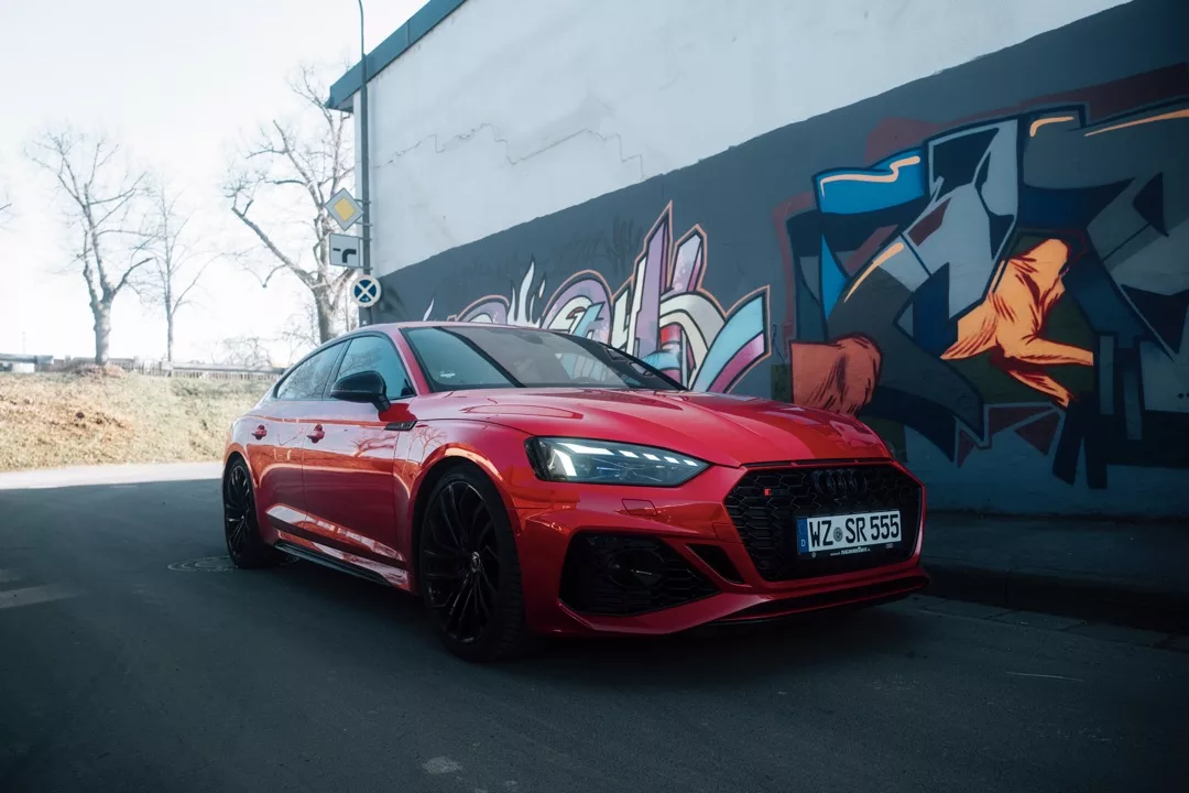 Audi RS5 Sportback in Rot vor Graffiti mieten