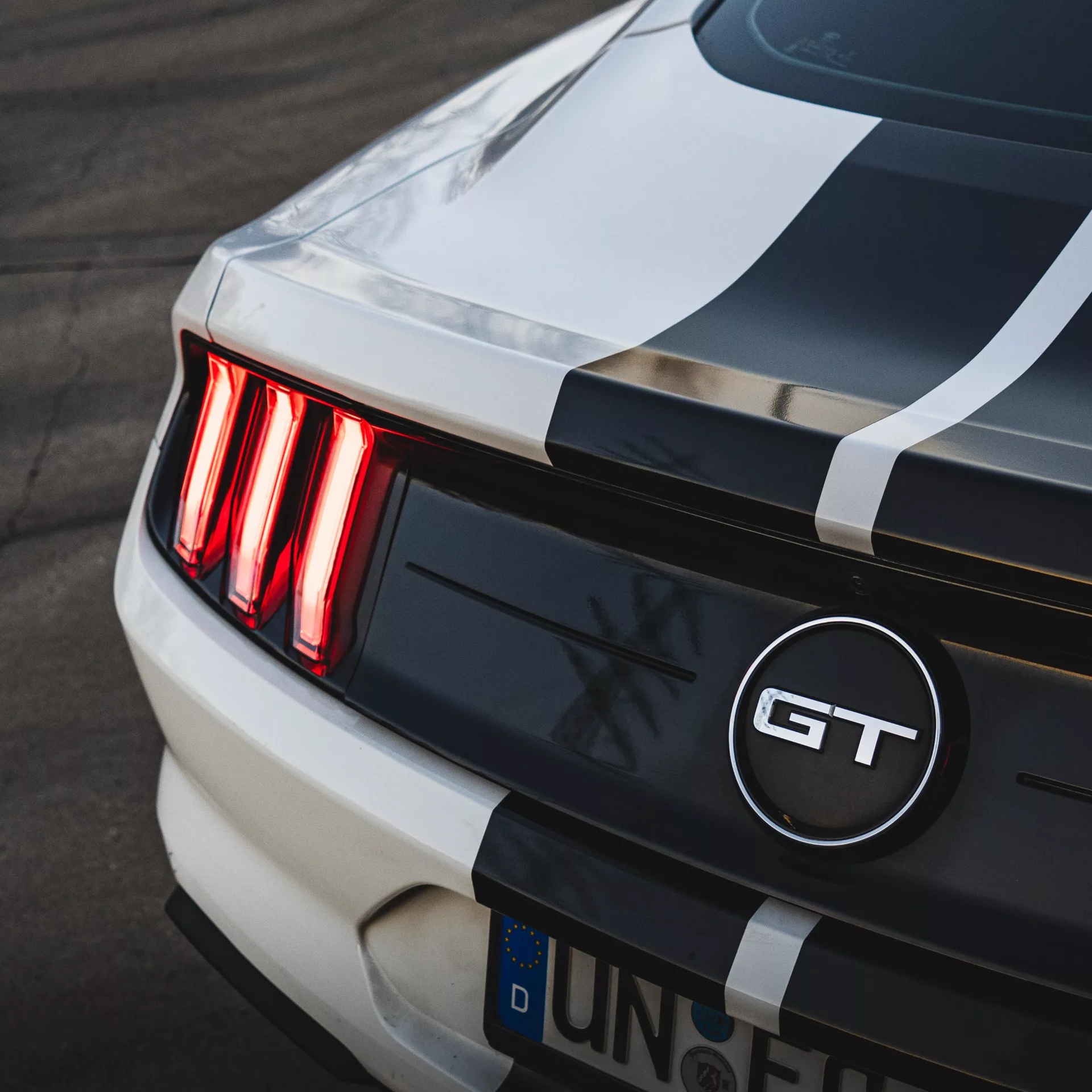 Ford Mustang GT Rückansicht mit Streifen und Leuchten mieten